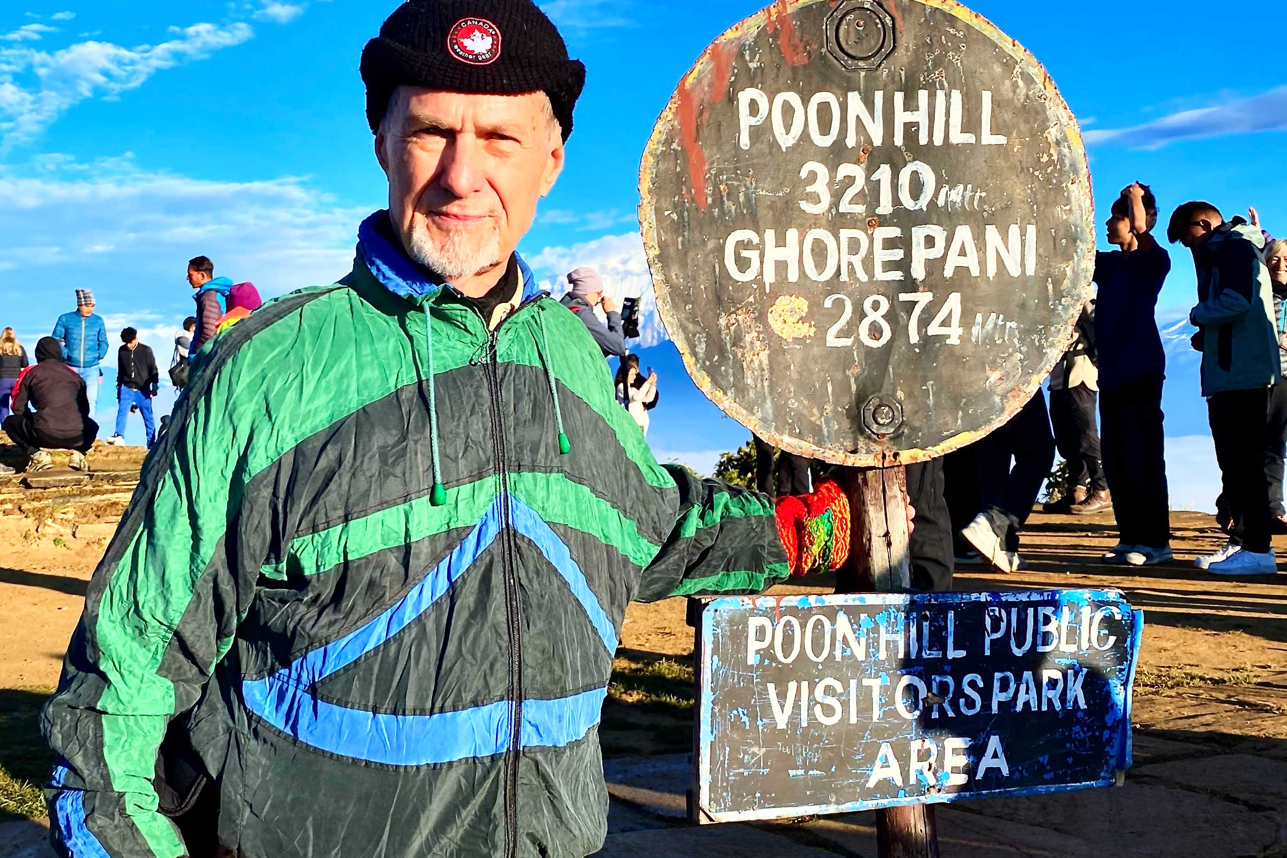 James Arnold stands by a mile marker on Poon Hill opposite Mount Annapurna in Nepal 