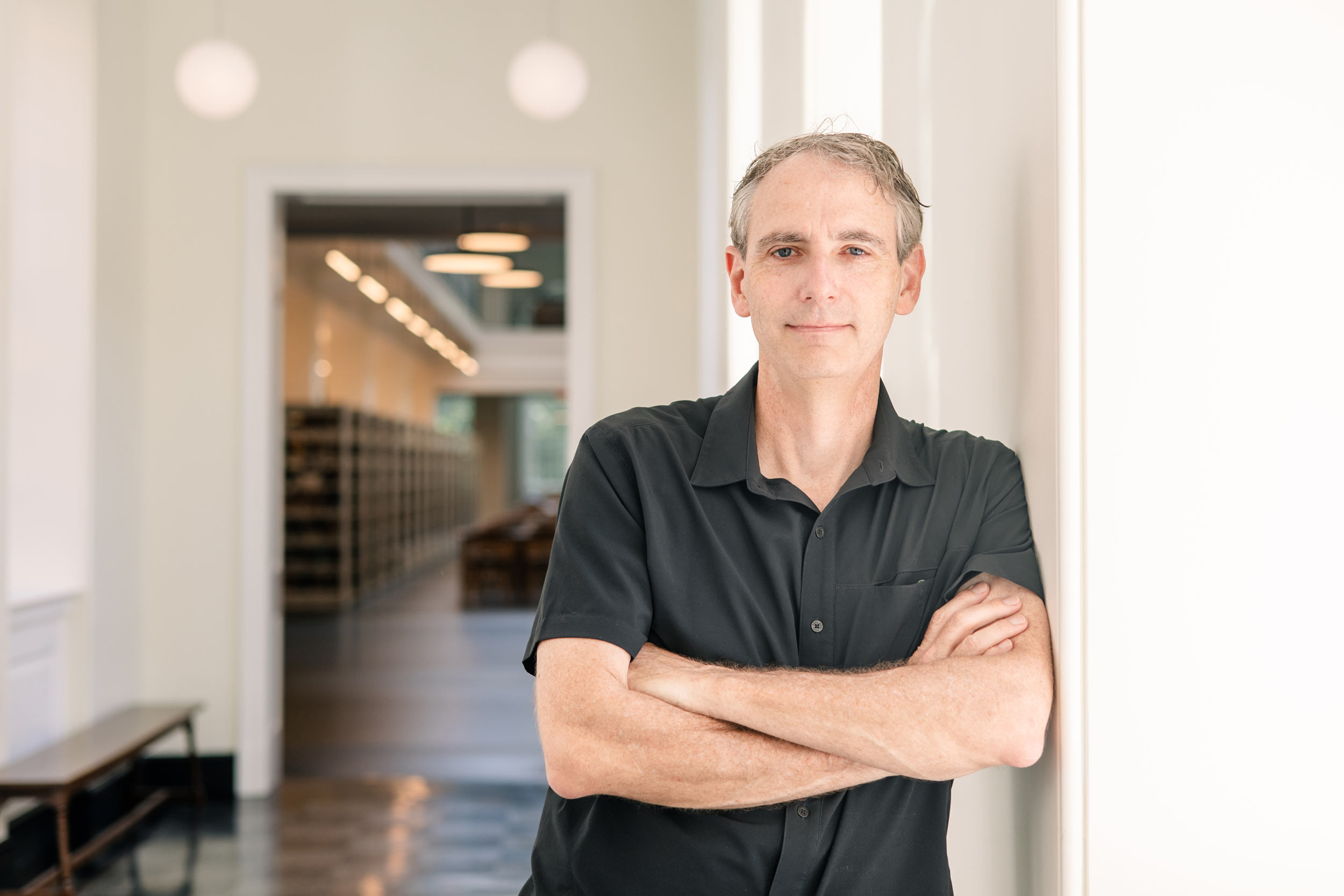 Bruce Holsinger posing for a portrait in the UVA Shannon Library
