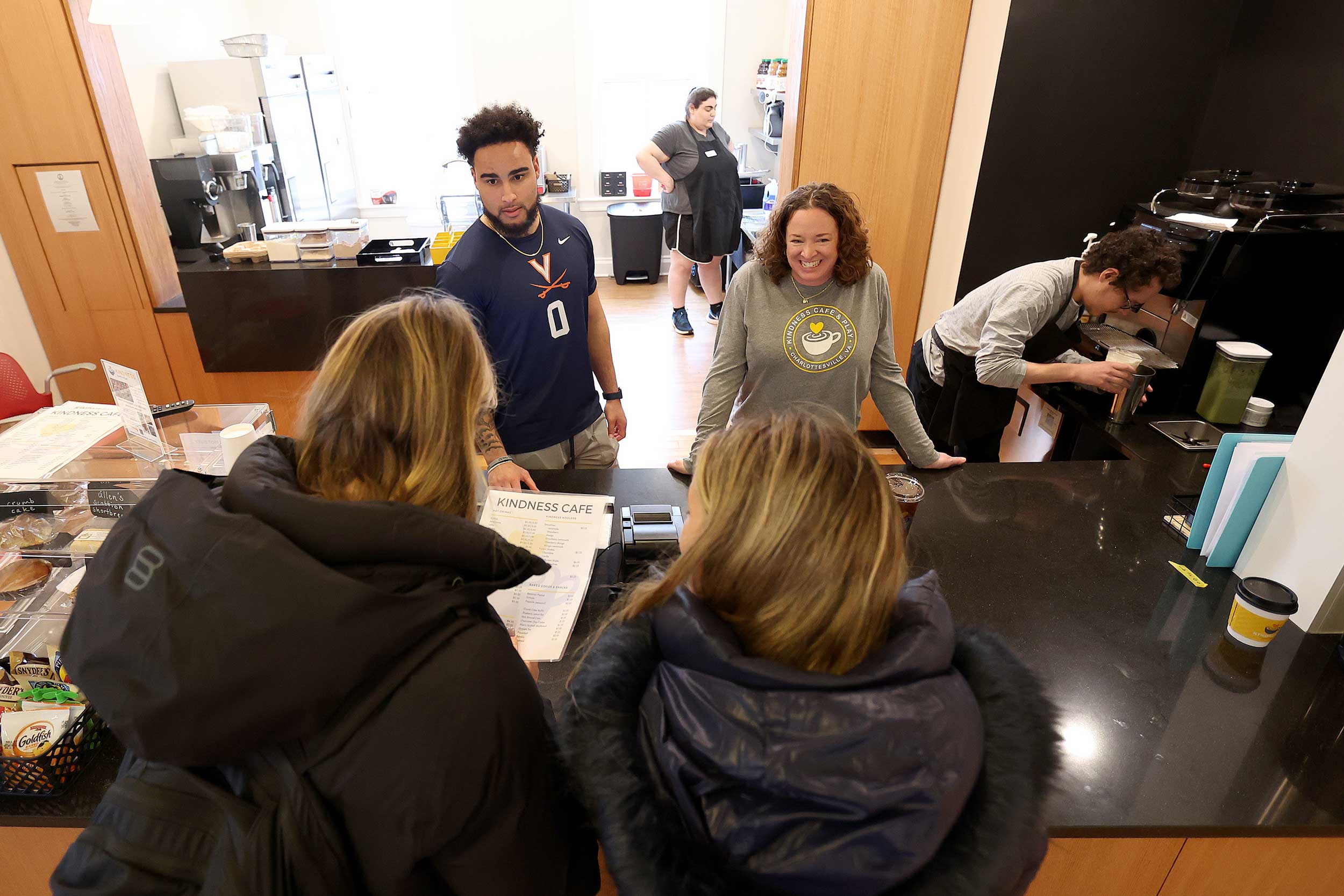 A portrait of Antonio Clary, a UVA football player, volunteering, and café manager Regan Stillerman serving coffee to a customer.