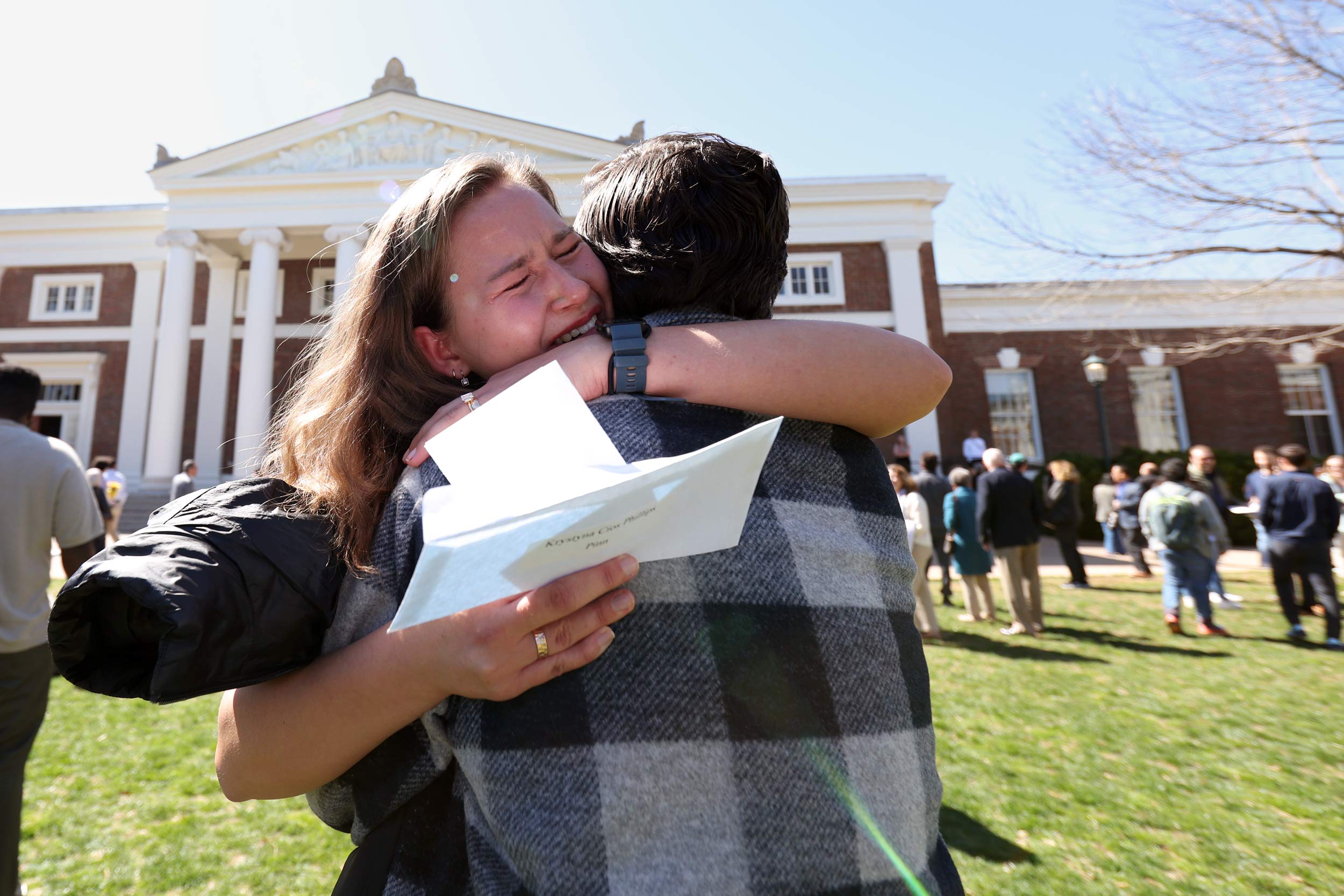 A student and their fiancé, in an emotional embrace, celebrating