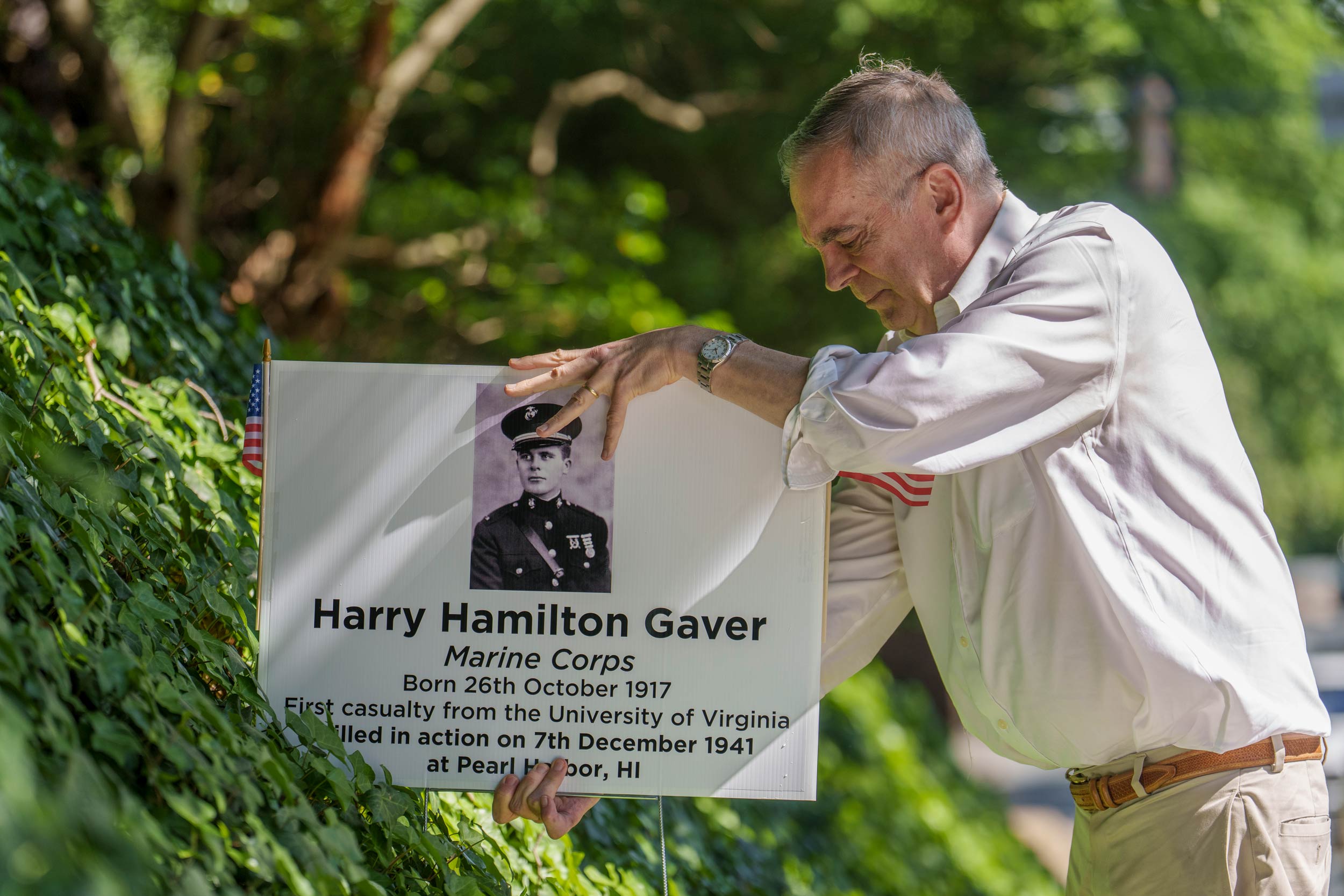 Greg Saathoff placing a yard sign about Harry Hamilton Gaver