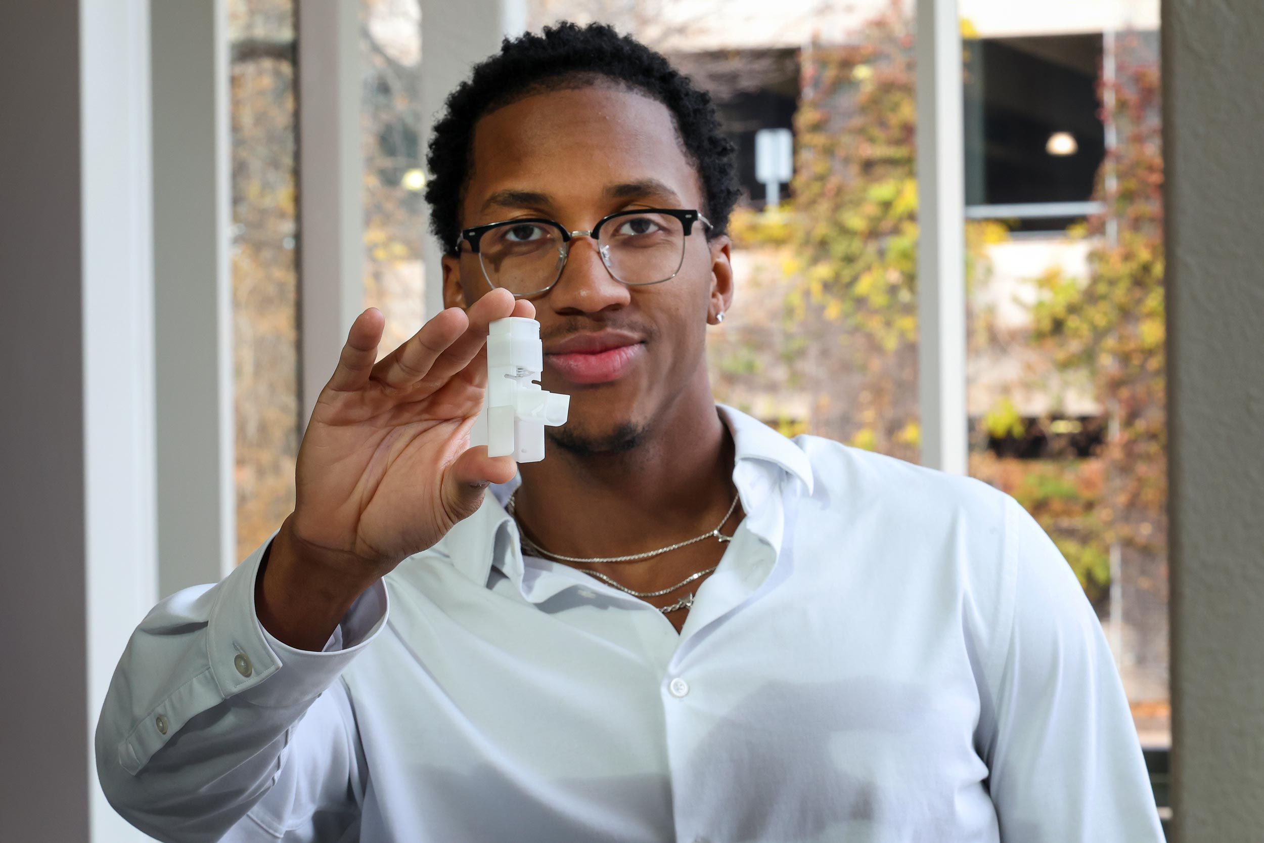 Miles Lanham holding out an example of his medical rescue device.