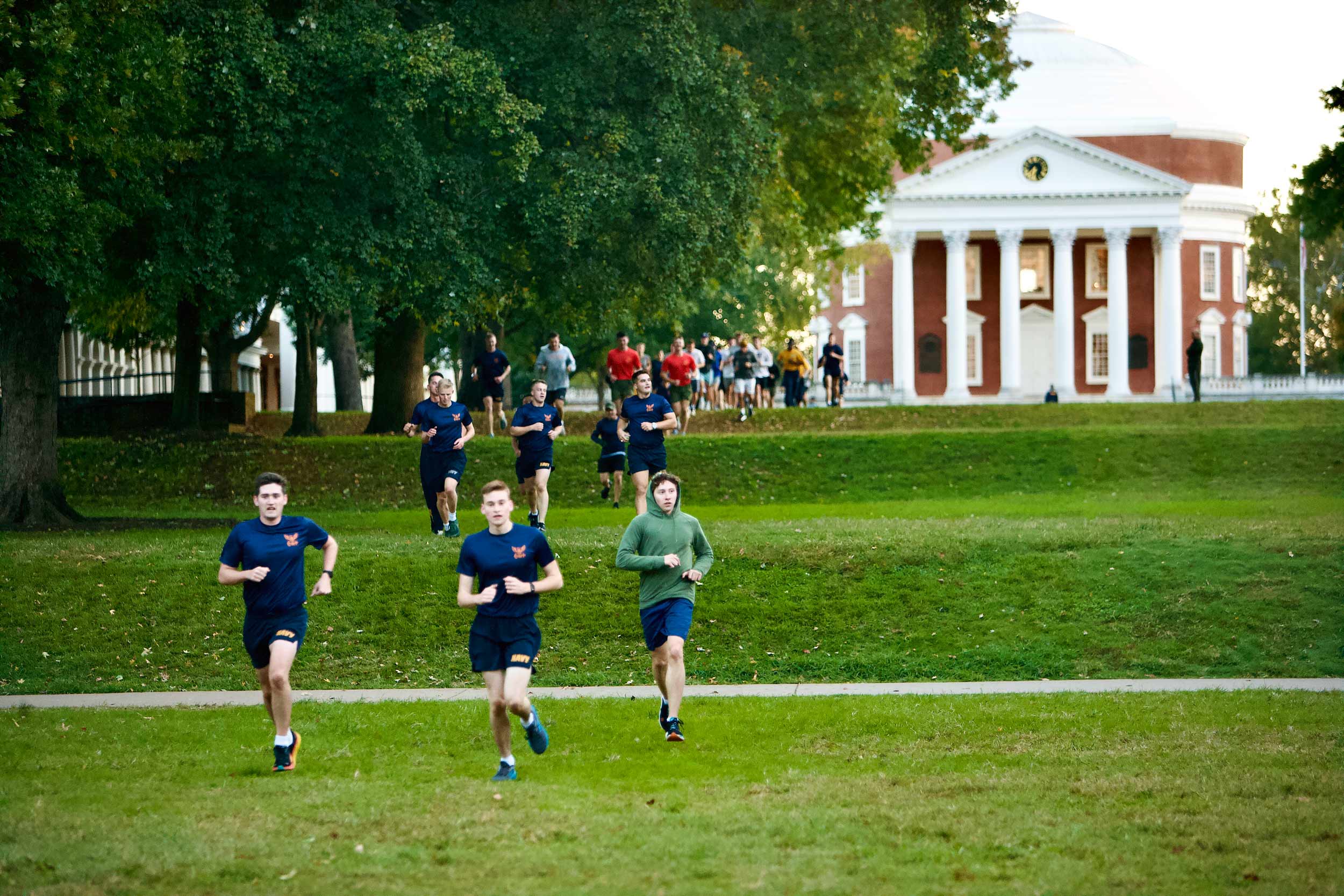 Naval ROTC and students run in front of the Rotunda