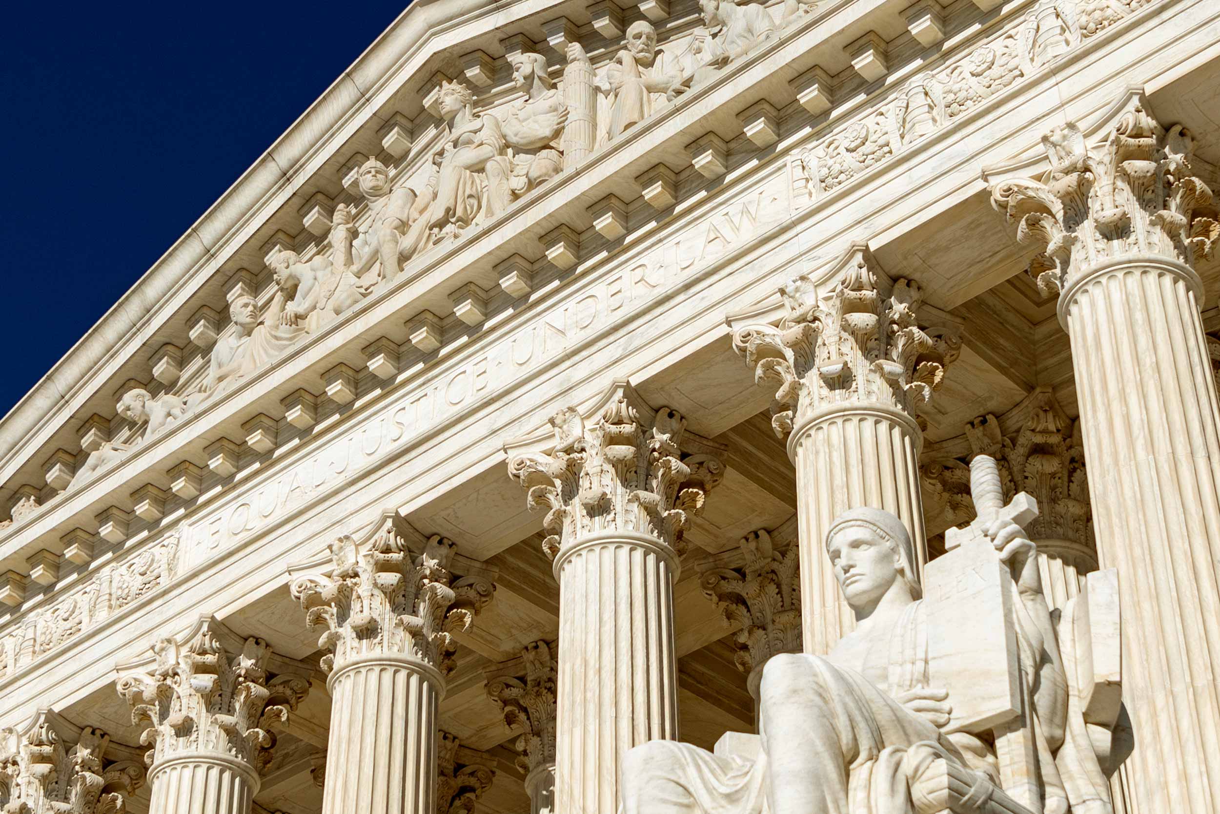 A close up view of the top of the Supreme Court building