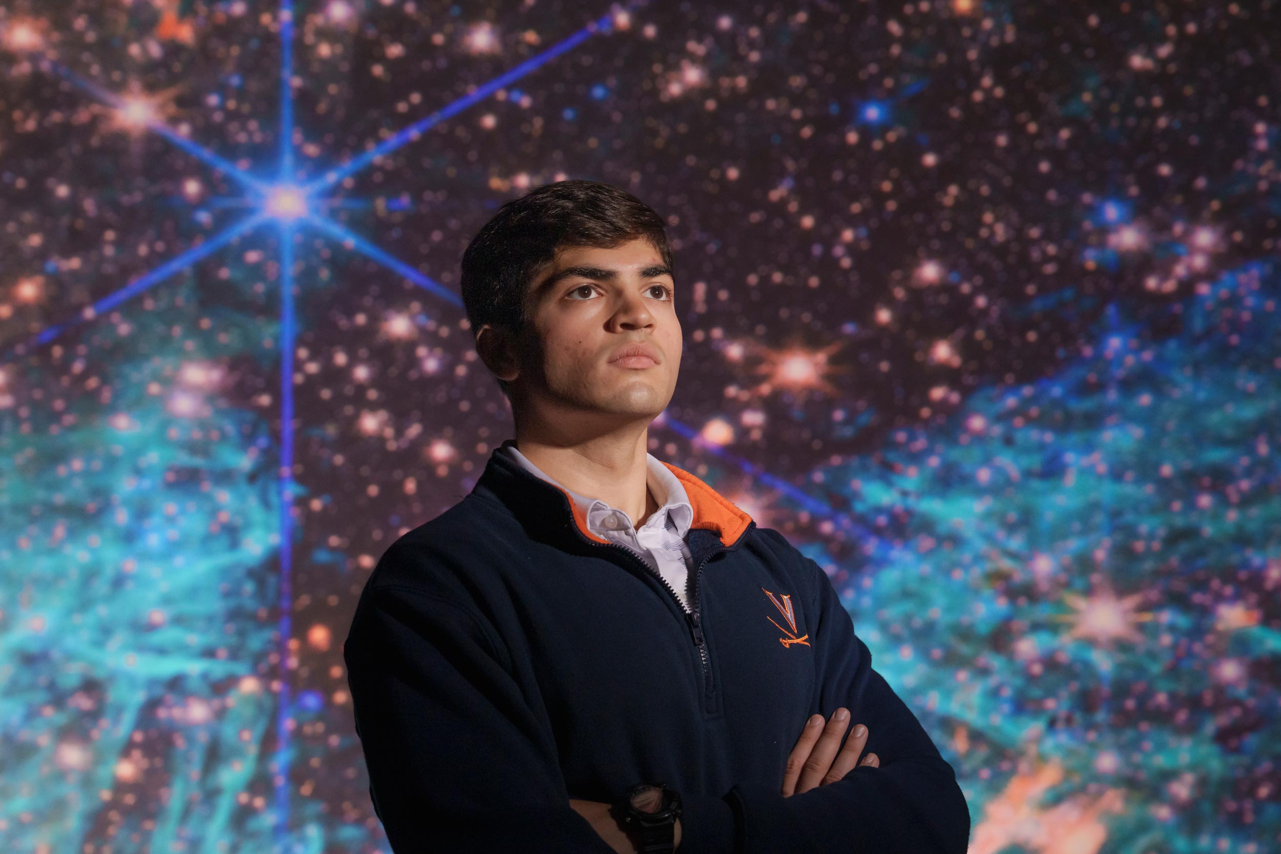 Portrait of Sam Crowe in front of a digital display of deep space