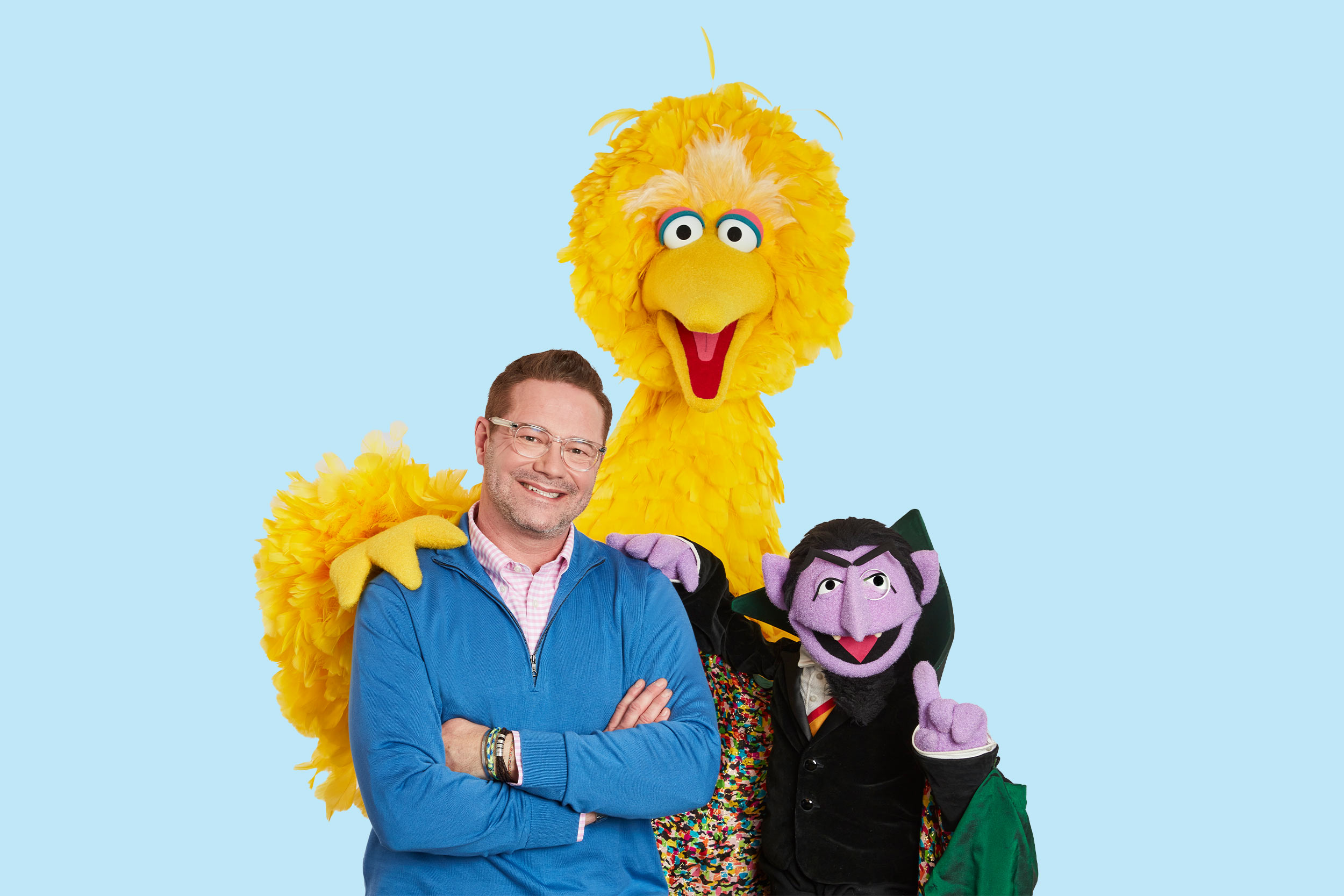 A portrait of Matt Vogel with Sesame Street characters Big Bird and Count von Count.