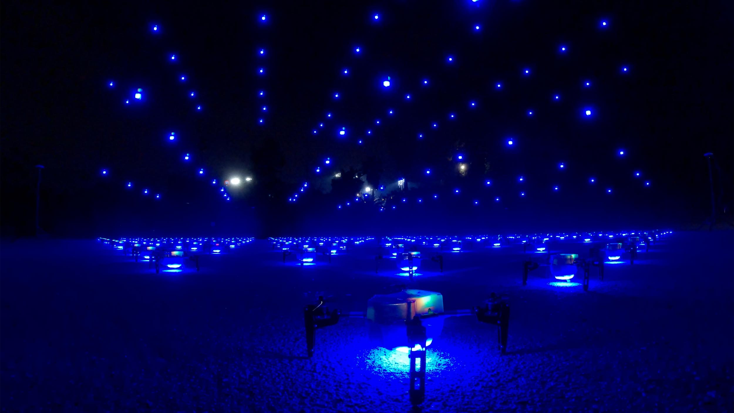 Drones lifting off the ground at night in unison 