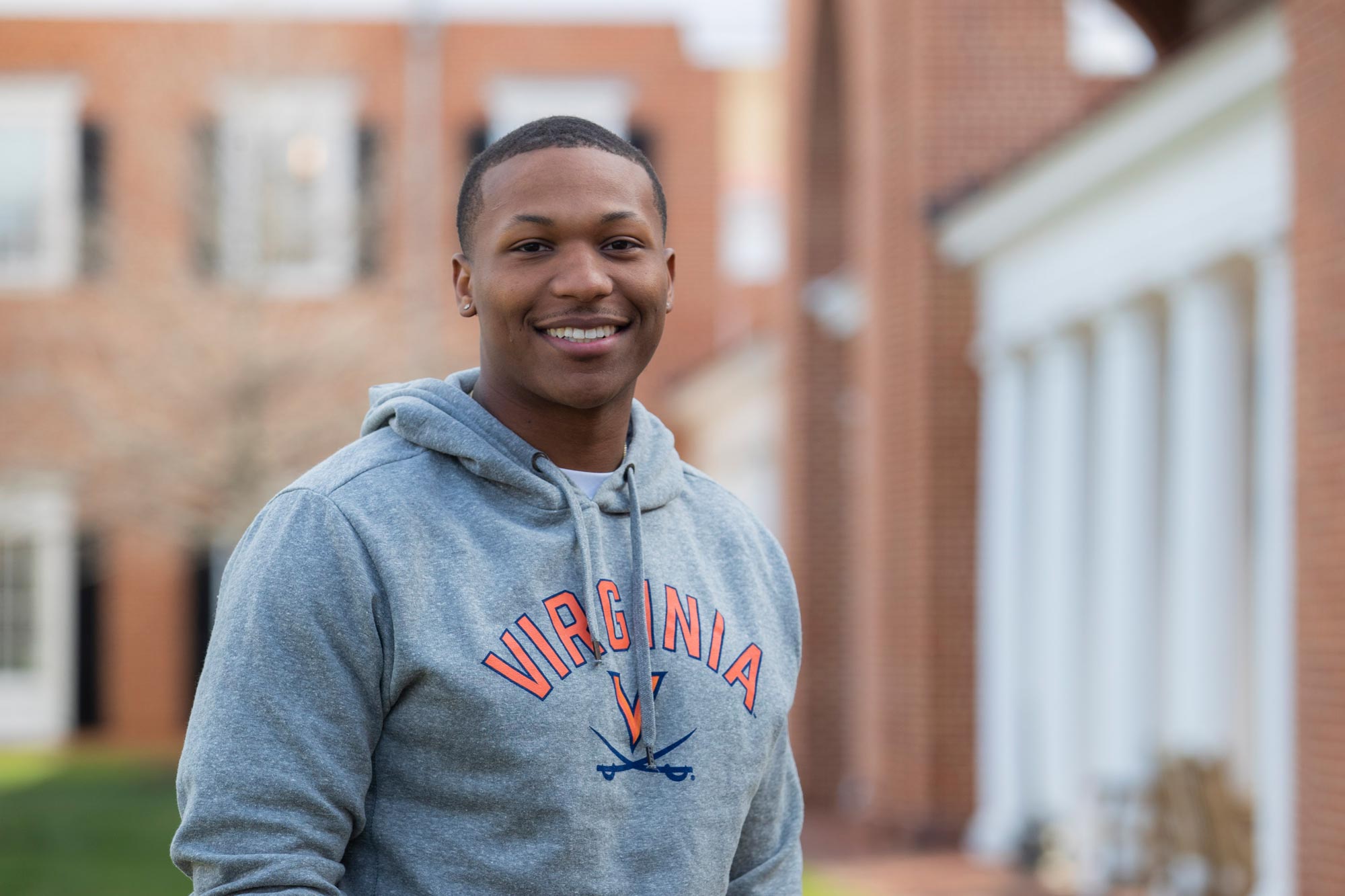 Antonio Brodie Jr. wears a gray sweatshirt with the Virginia Cavaliers logo and smiles at the camera