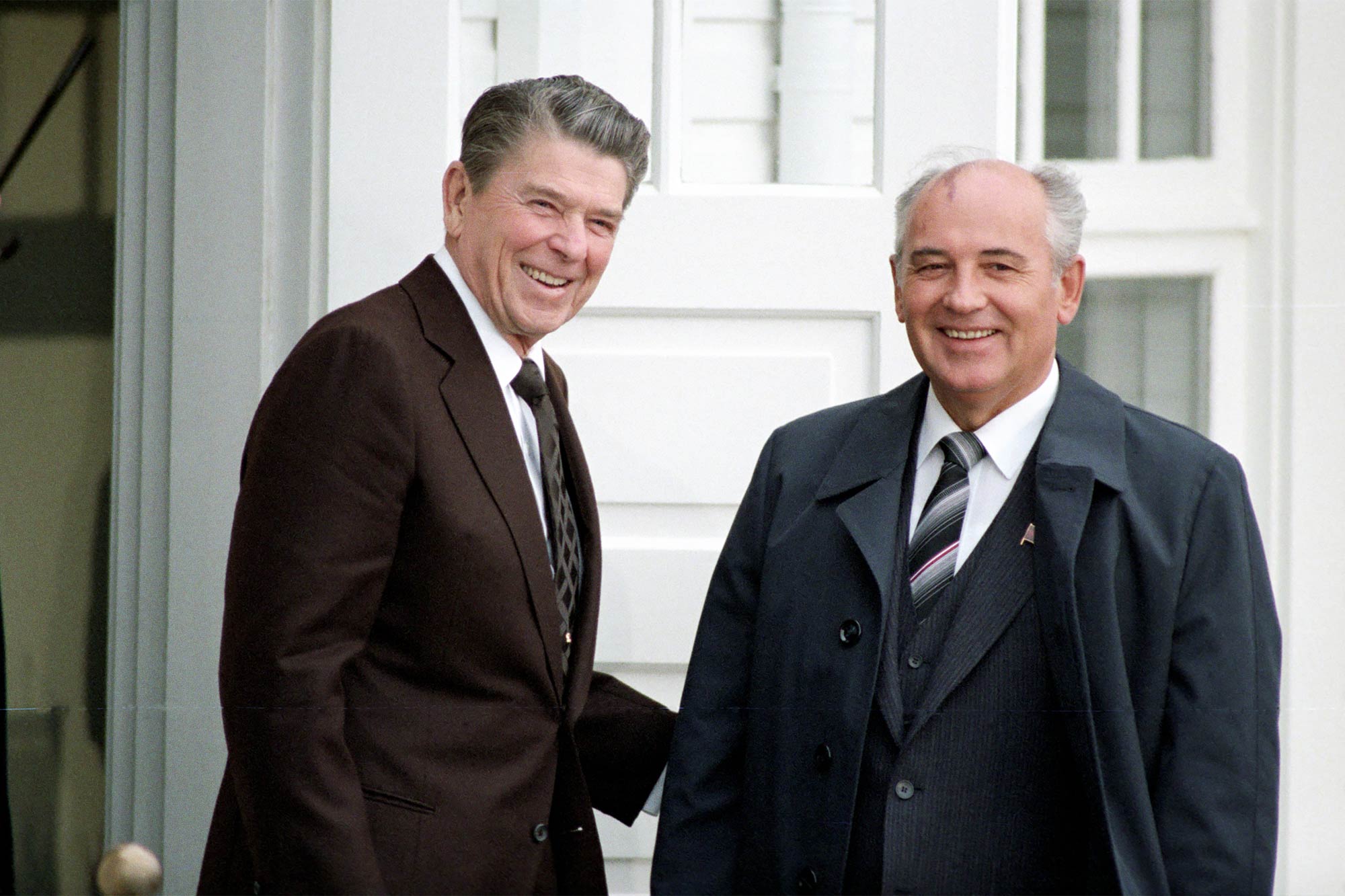 Ronald Reagan and Mikhail Gorbachev stand together and smile