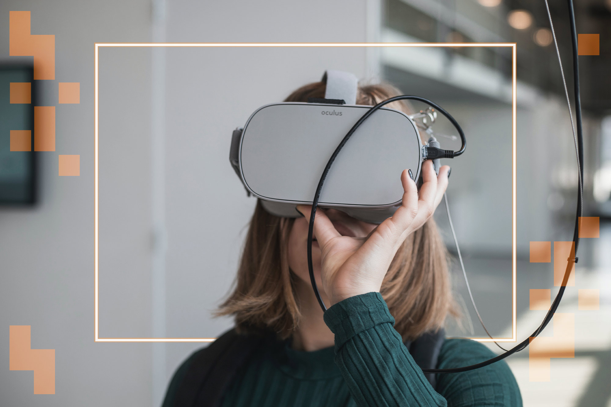A woman holds a pair of VR goggles to her face