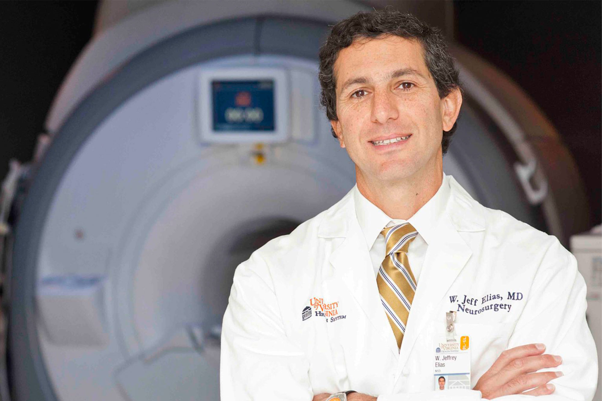 Portrait of UVA neurosurgeon Dr. Jeff Elias in front of medical machinery 