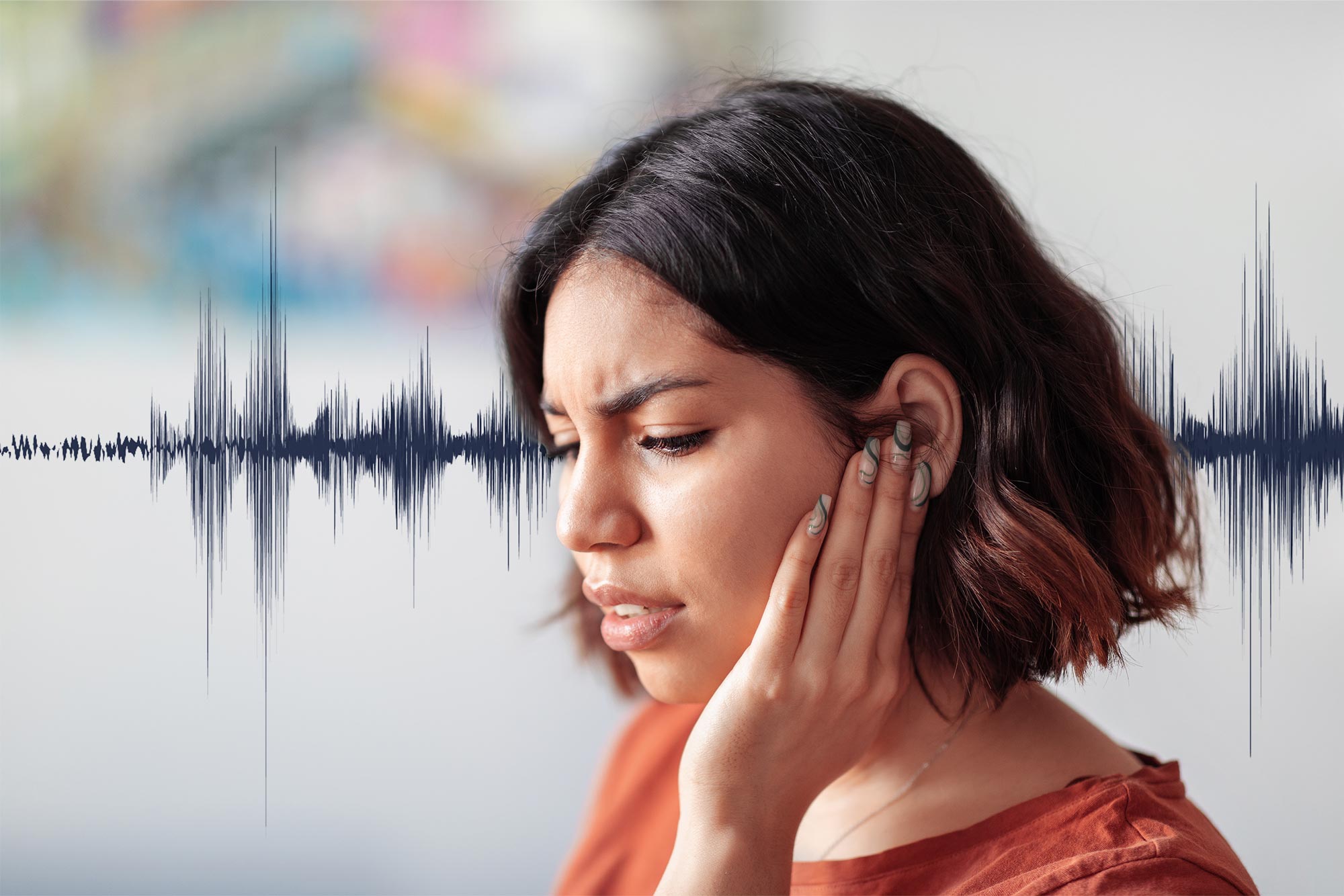 Woman covering her ear with a soundwave in the background of the photo