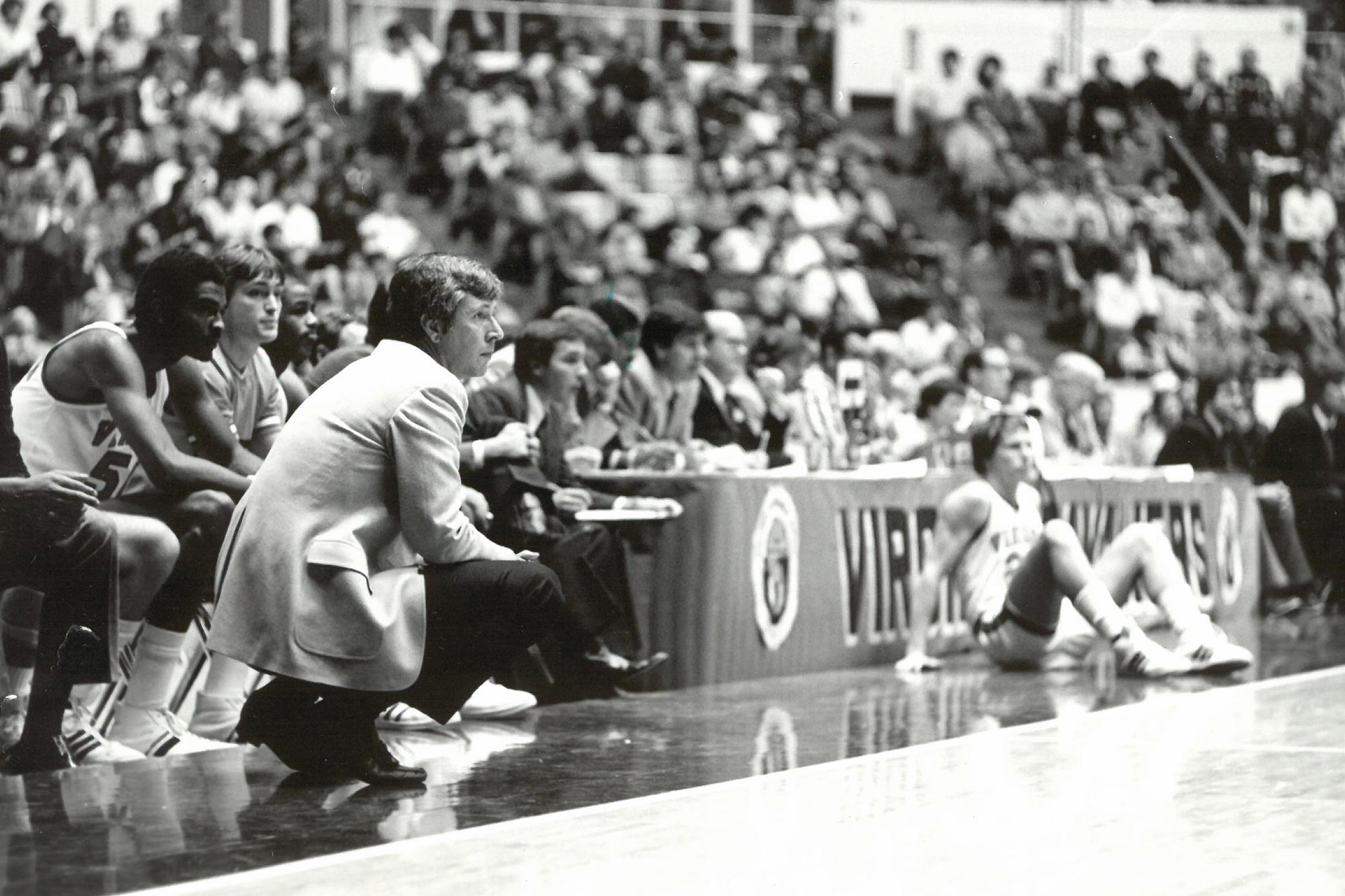 Terry Holland knelt down on the court watching the Cavaliers 