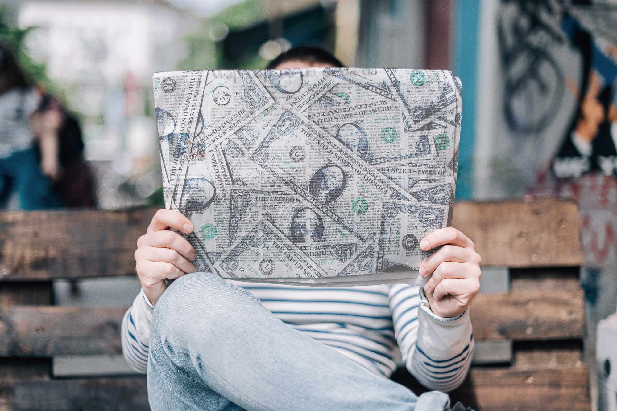 Illustration of a person reading a newspaper made out of dollars