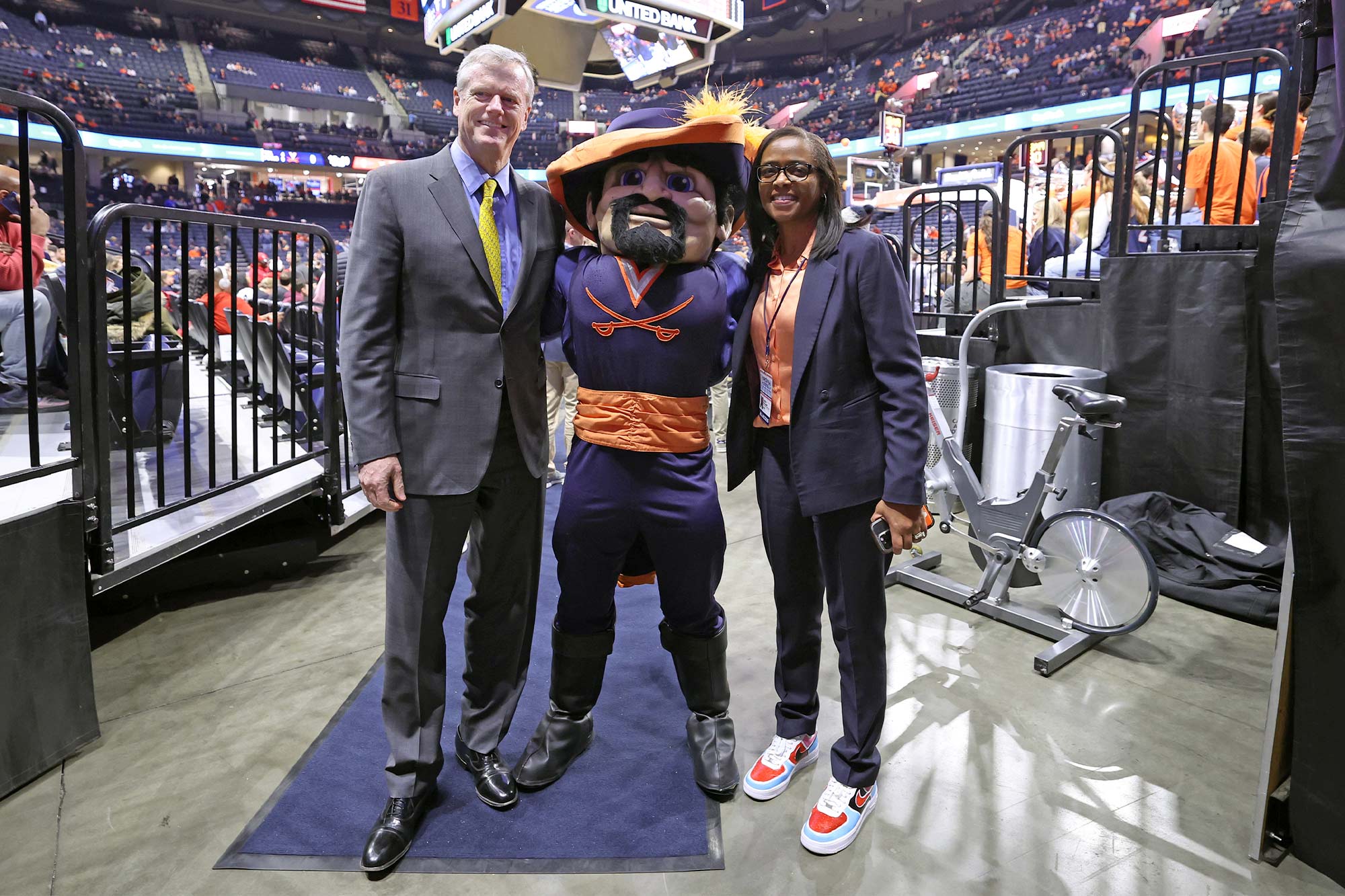 Carla Williams, Cav Man and Charlie Baker stand together in the John Paul Jones Arena 