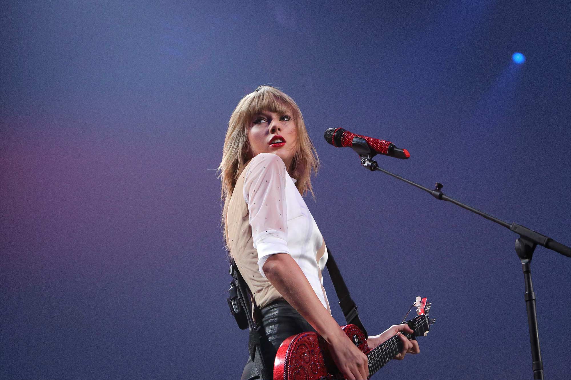 Taylor Swift looking over her shoulder during a live performance