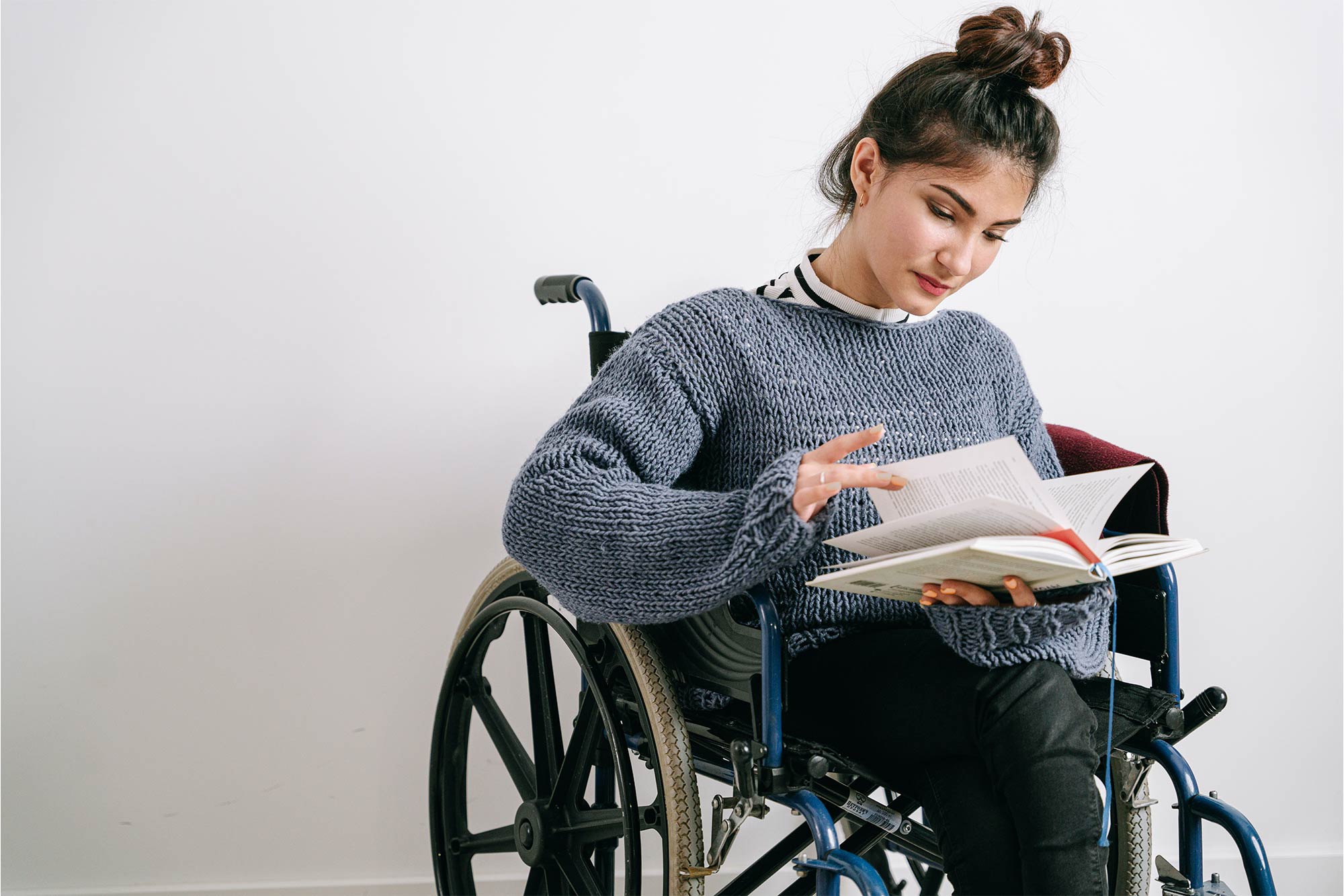 A woman in a wheelchair reads a book