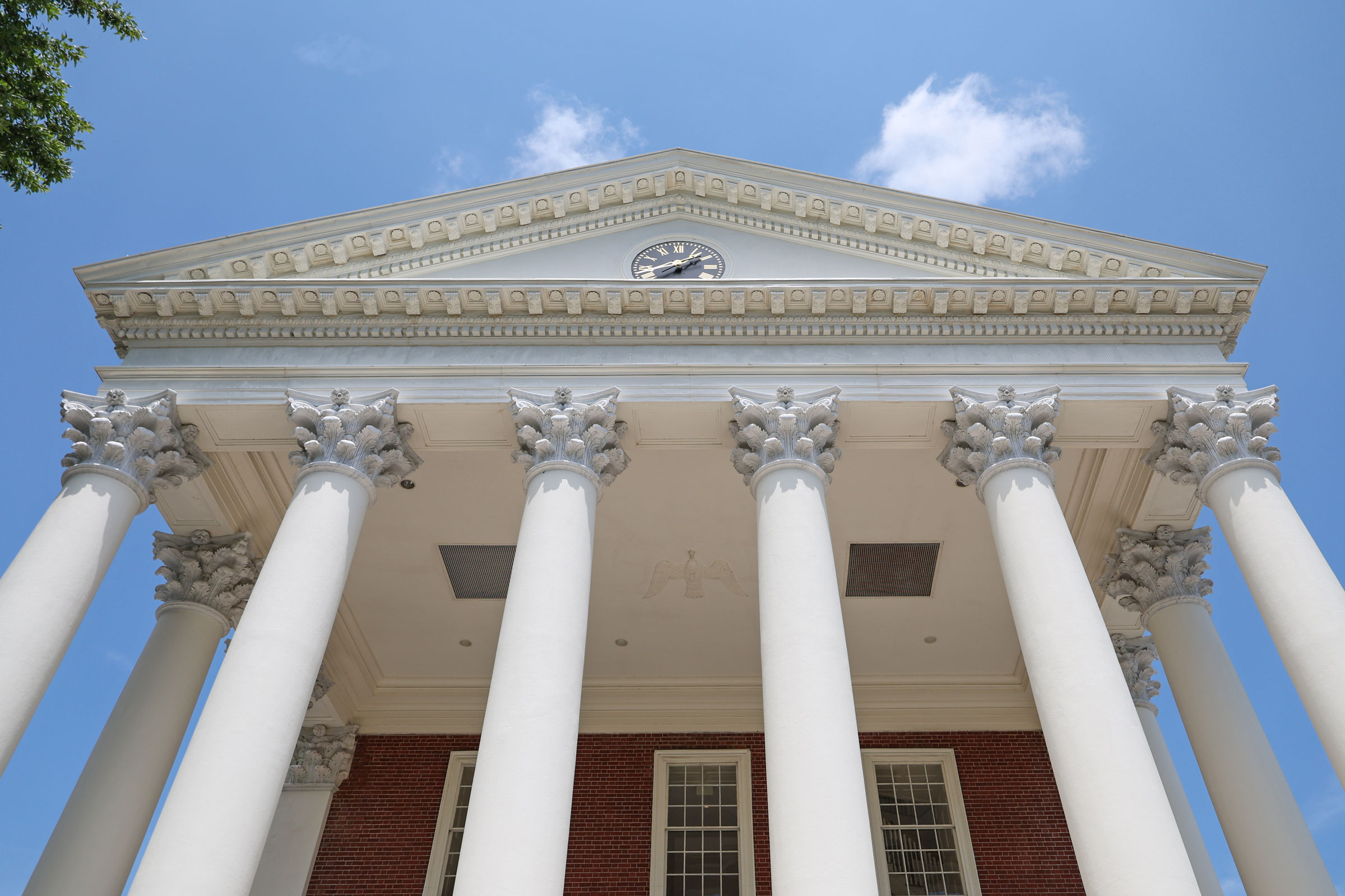 looking up at the capitals of the columns on the Rotunda building on a clear afternoon