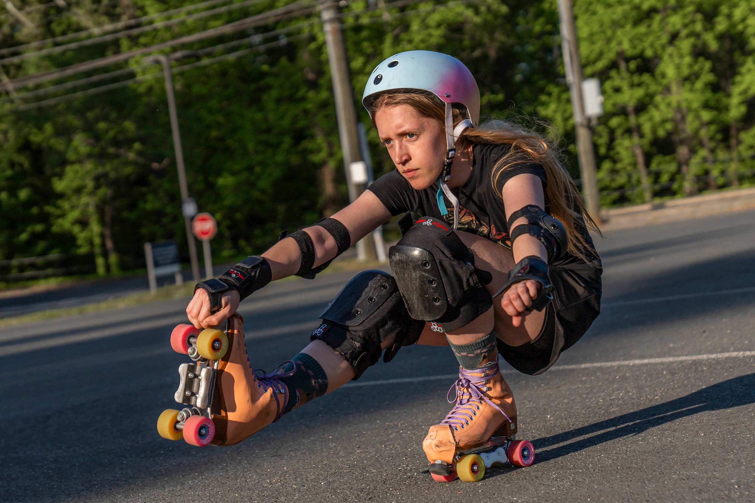 Reese Robers skating in a squat position on only one skate in a parking lot derby practice