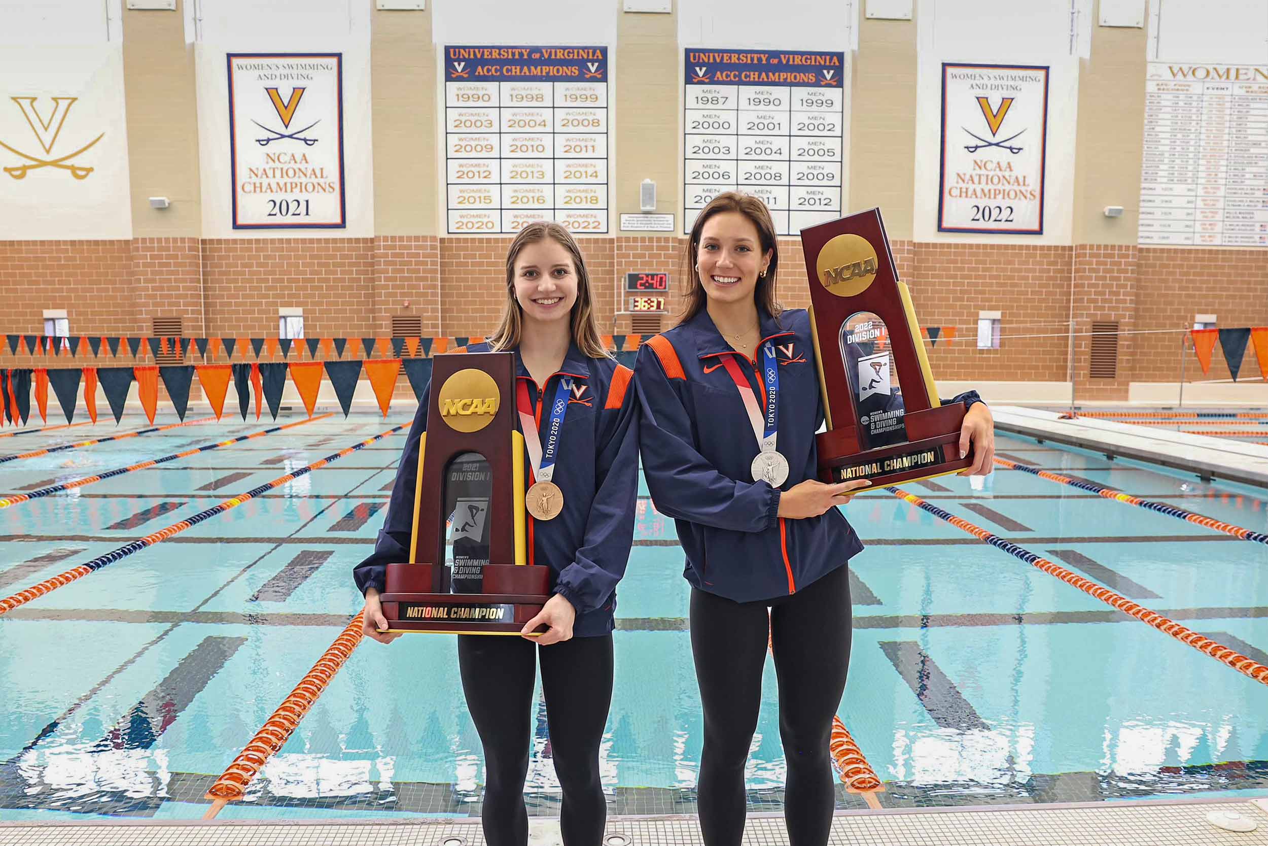 Candid portrait of Kate Douglass and Alex Walsh with olympic medal and holding national championship trophy of women's swimming and diving