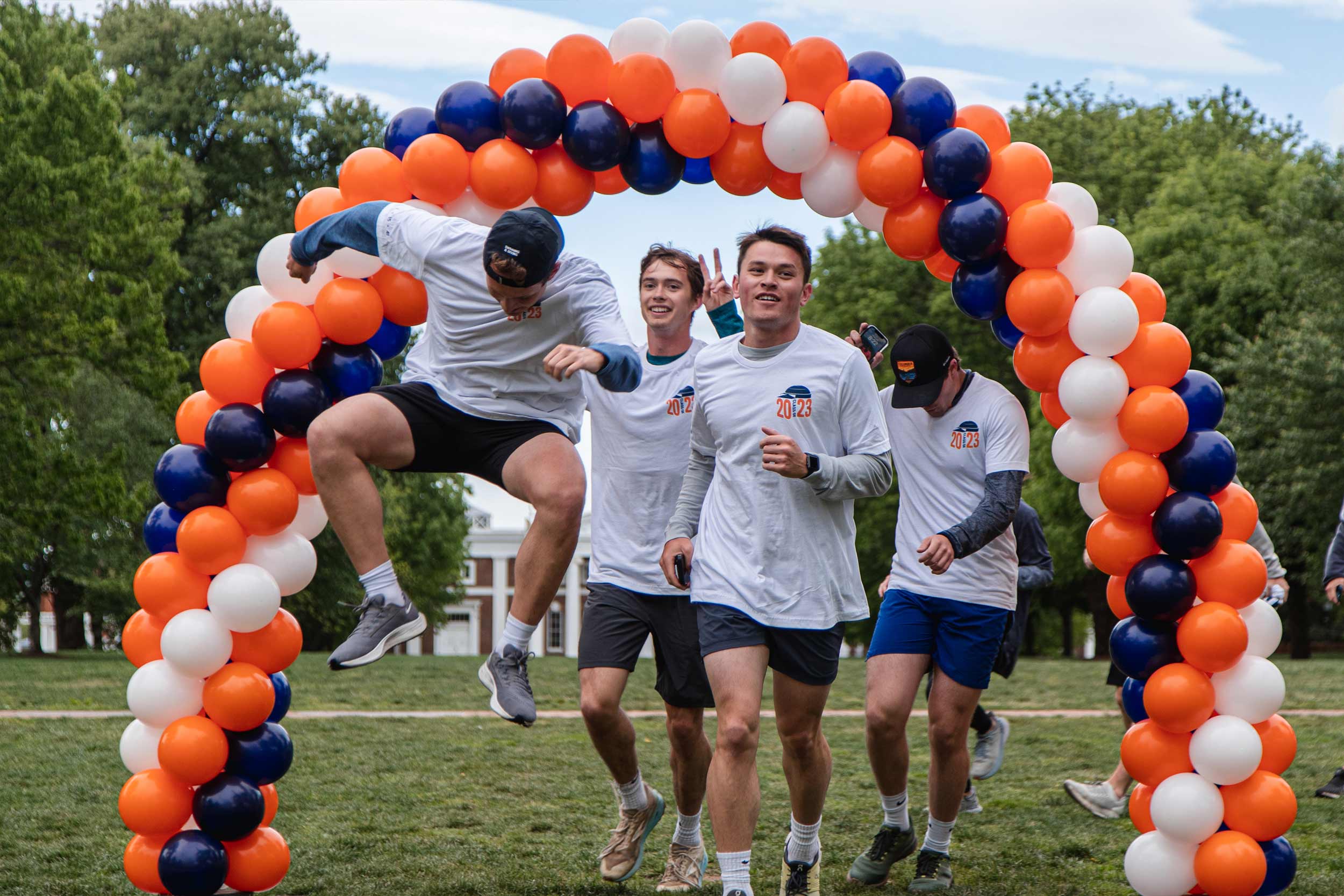 Fourth-year students on their final “Run With Jim” pass through balloon finish line