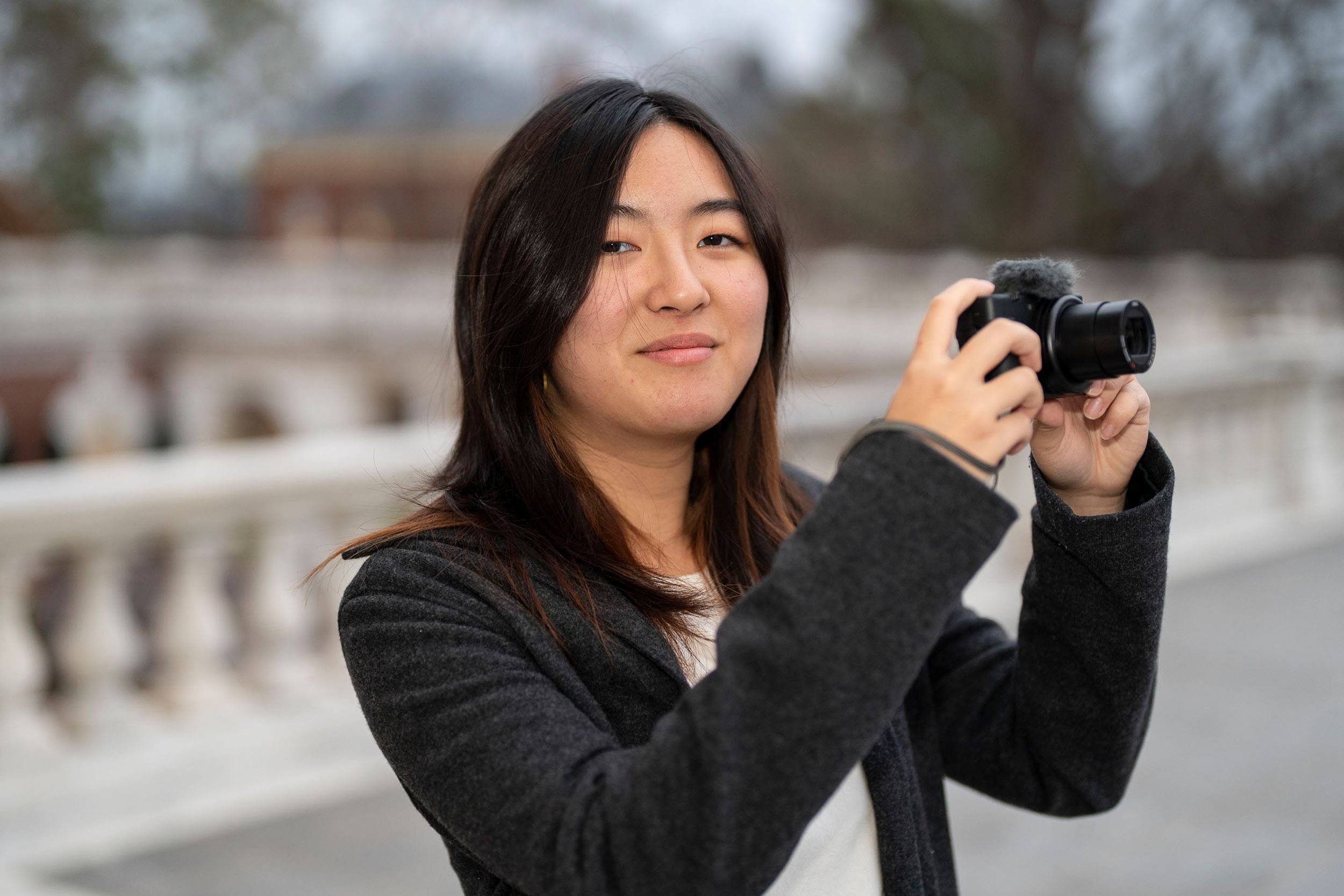 Portrait of Dillen Chung with her camera on grounds