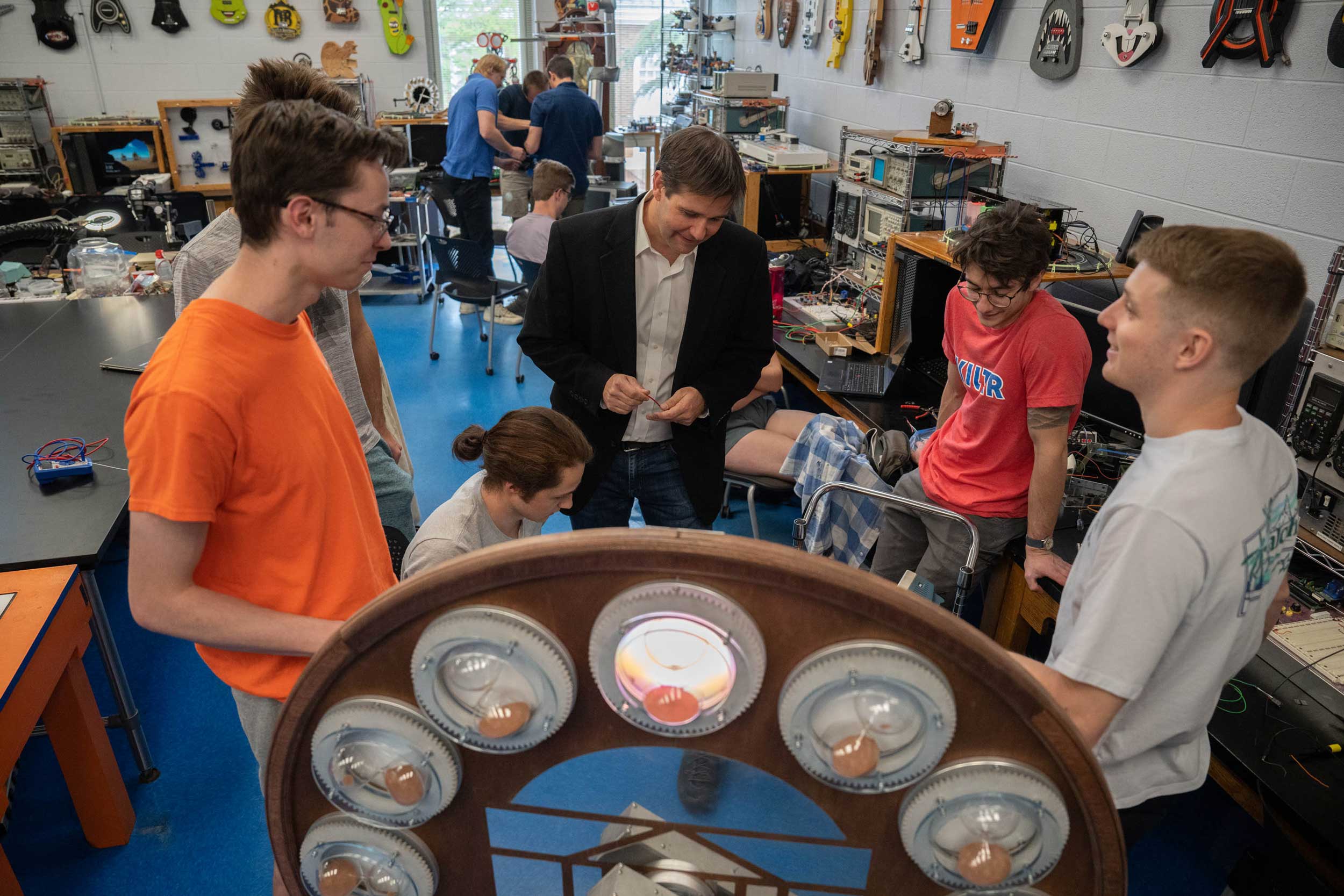 Students conversing around newly wired clock 