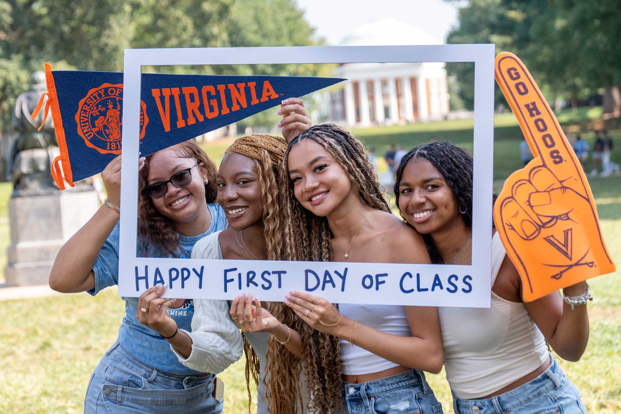 Group portrait of UVA students Nydja Randolph-Harris, Belcy Emerson, Summer Bui, and Amore Jackson holding a frame with the text 'Happy First Day of Class.'