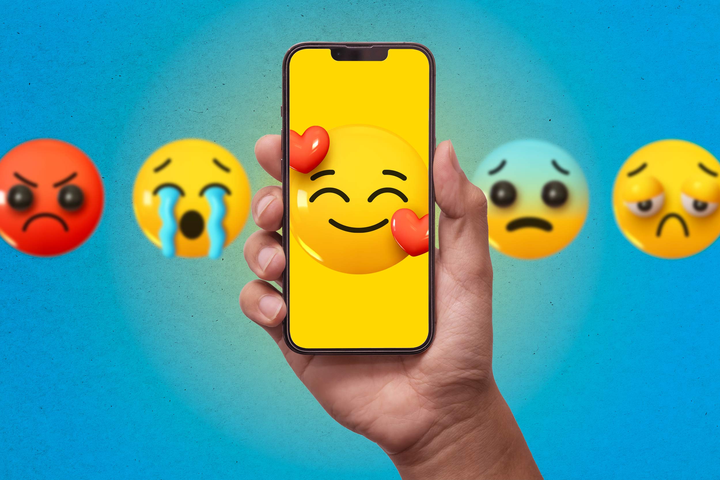 A hand holding up a phone screen with a smiling emoji face surrounded by hearts