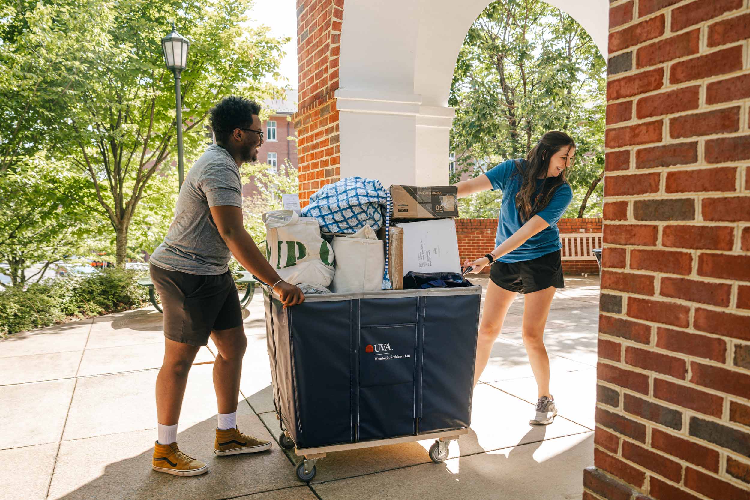 Two students push a cart full of move in items