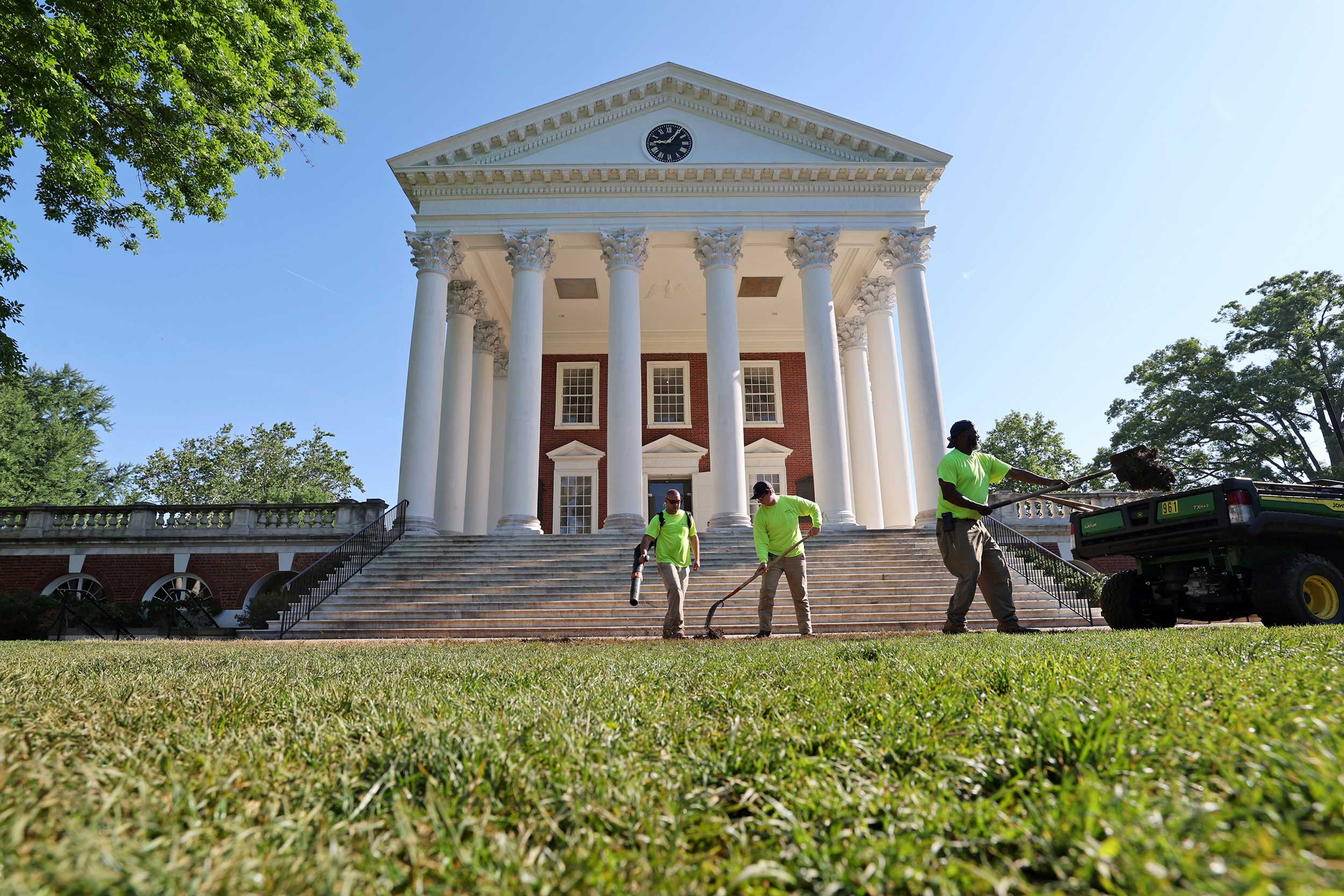Three landscapers work in front of the Rotunda to repair the Lawn