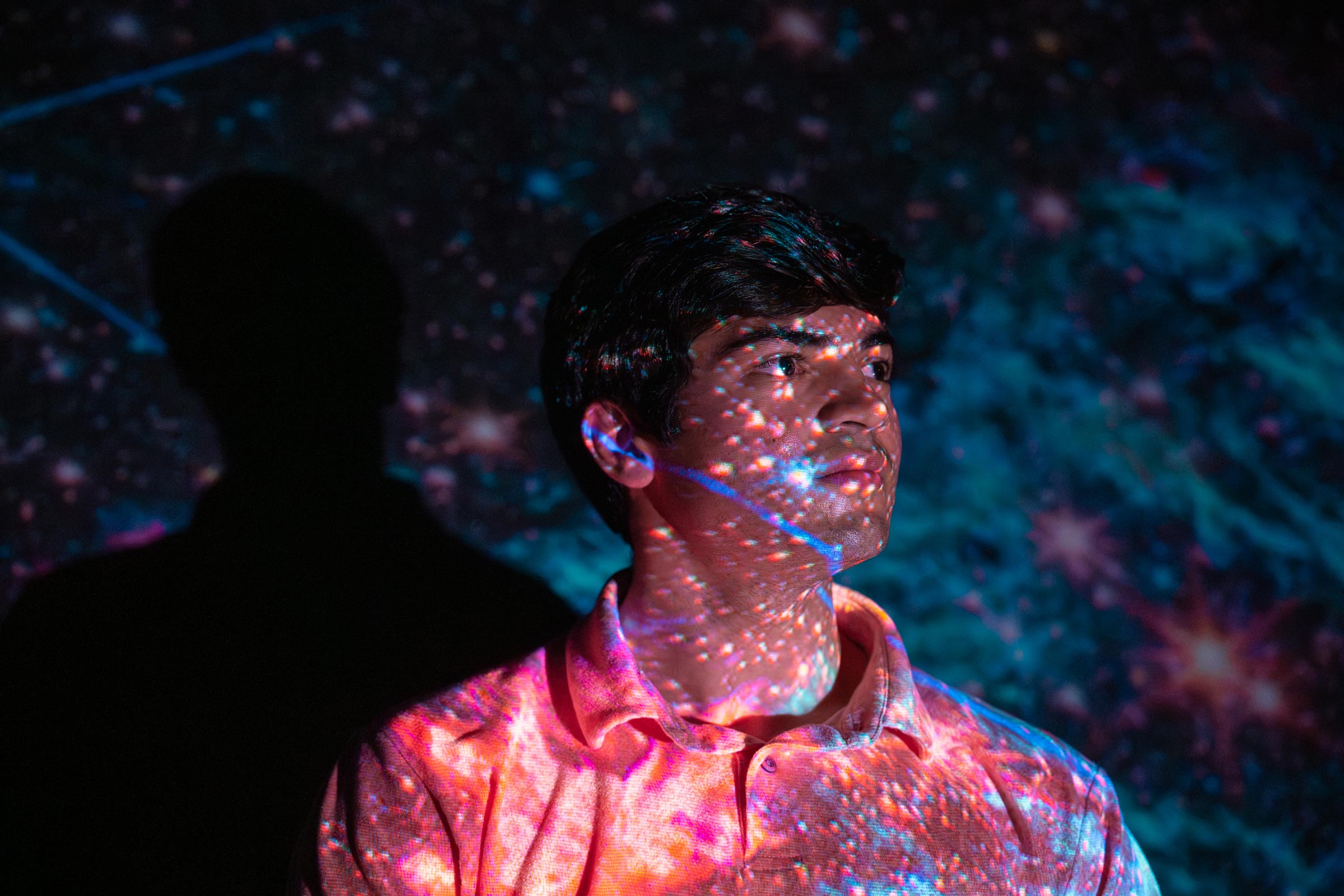 Rhodes Scholar Sam Crowe with galaxy lights shining over his face