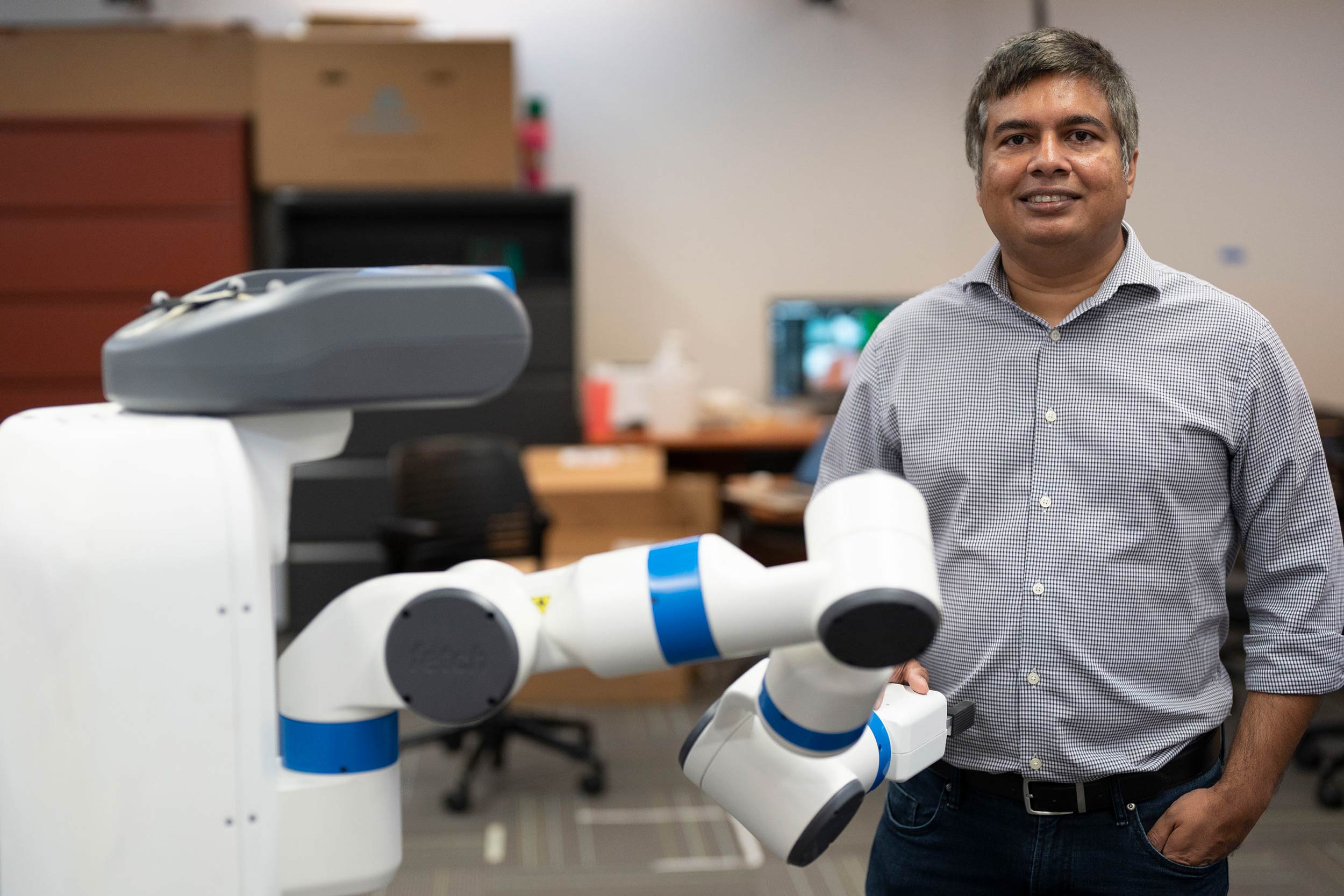 Portrait of Tariq Iqbal with a robot