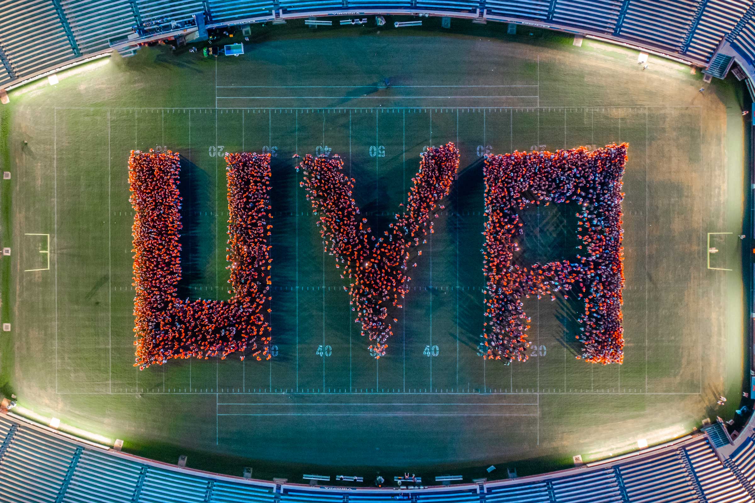 Drone shot of students forming "UVA" on the field