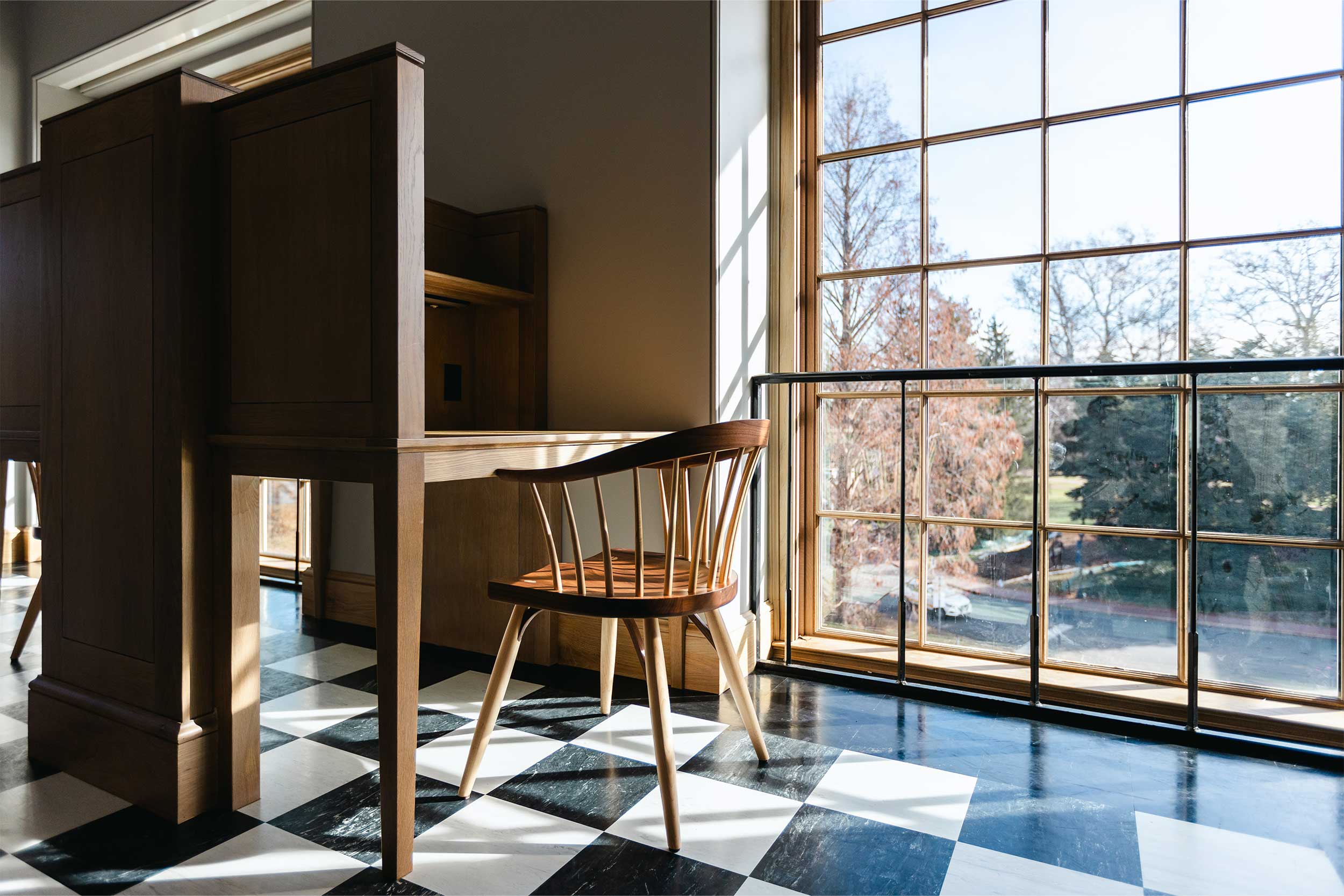 A wooden chair and desk by a window in Alderman