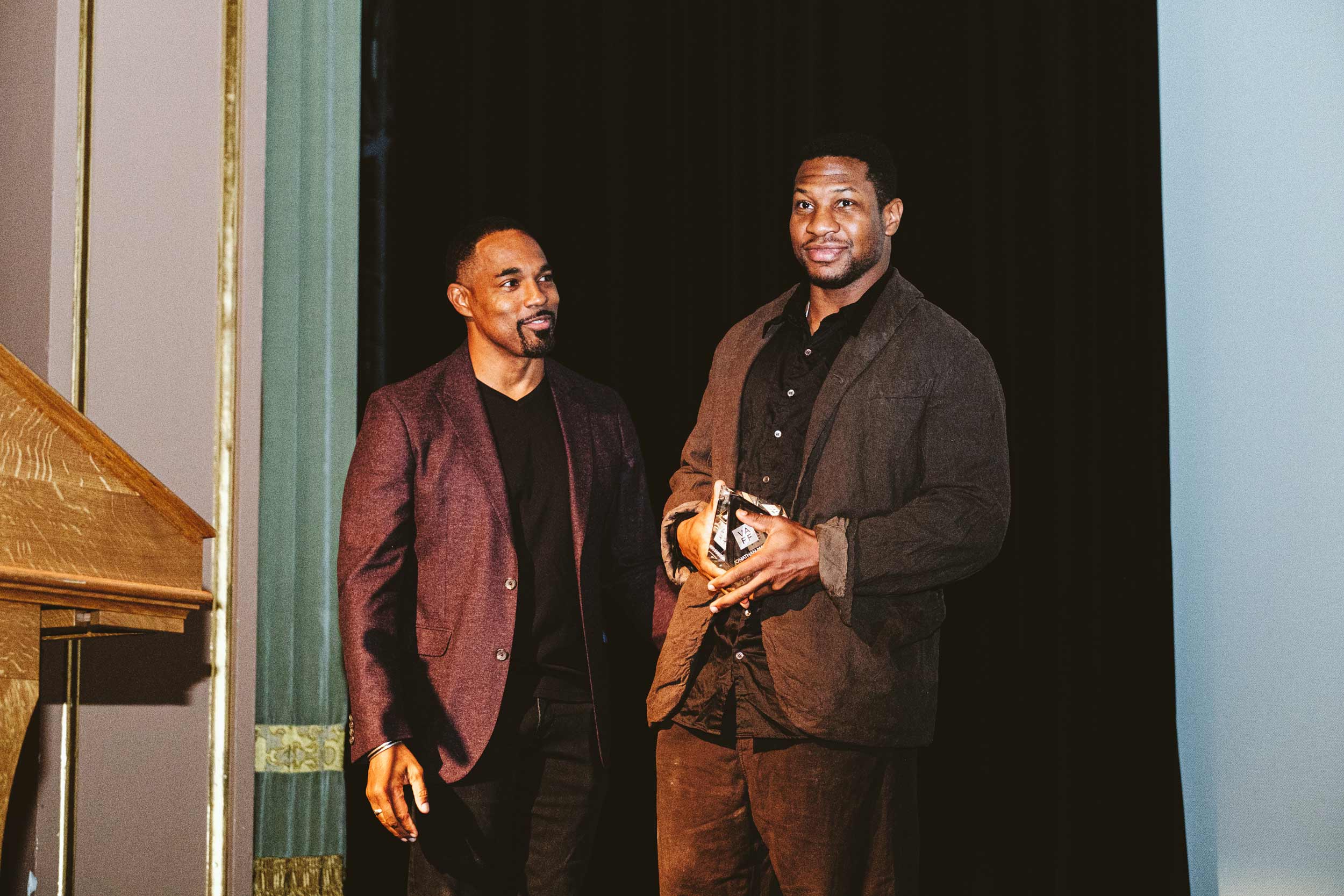 Two men standing on stage accepting an award