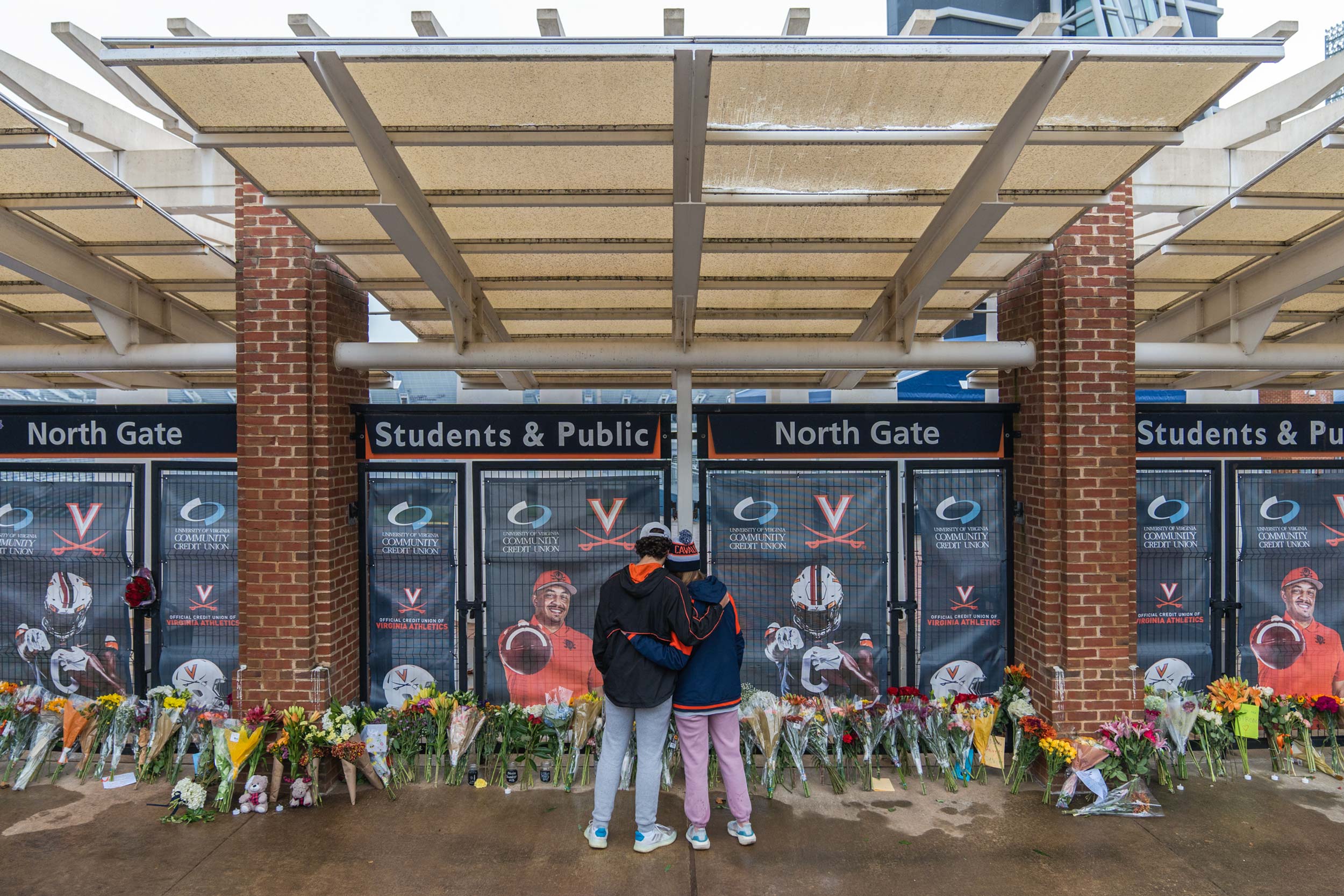 Students by a memorial outside Scott Stadium