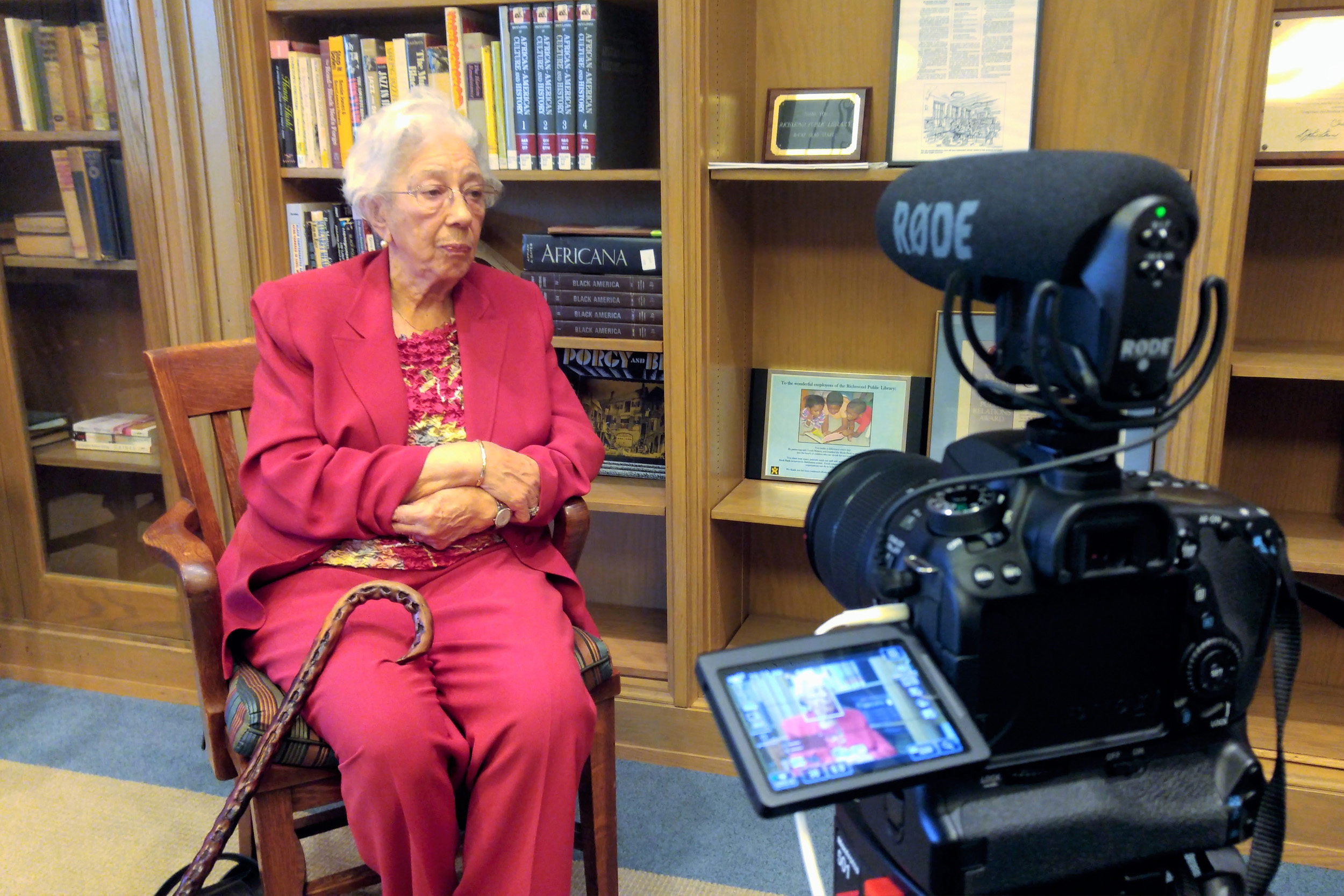 LaVerne Spurlock sitting in a chair while a camera records her