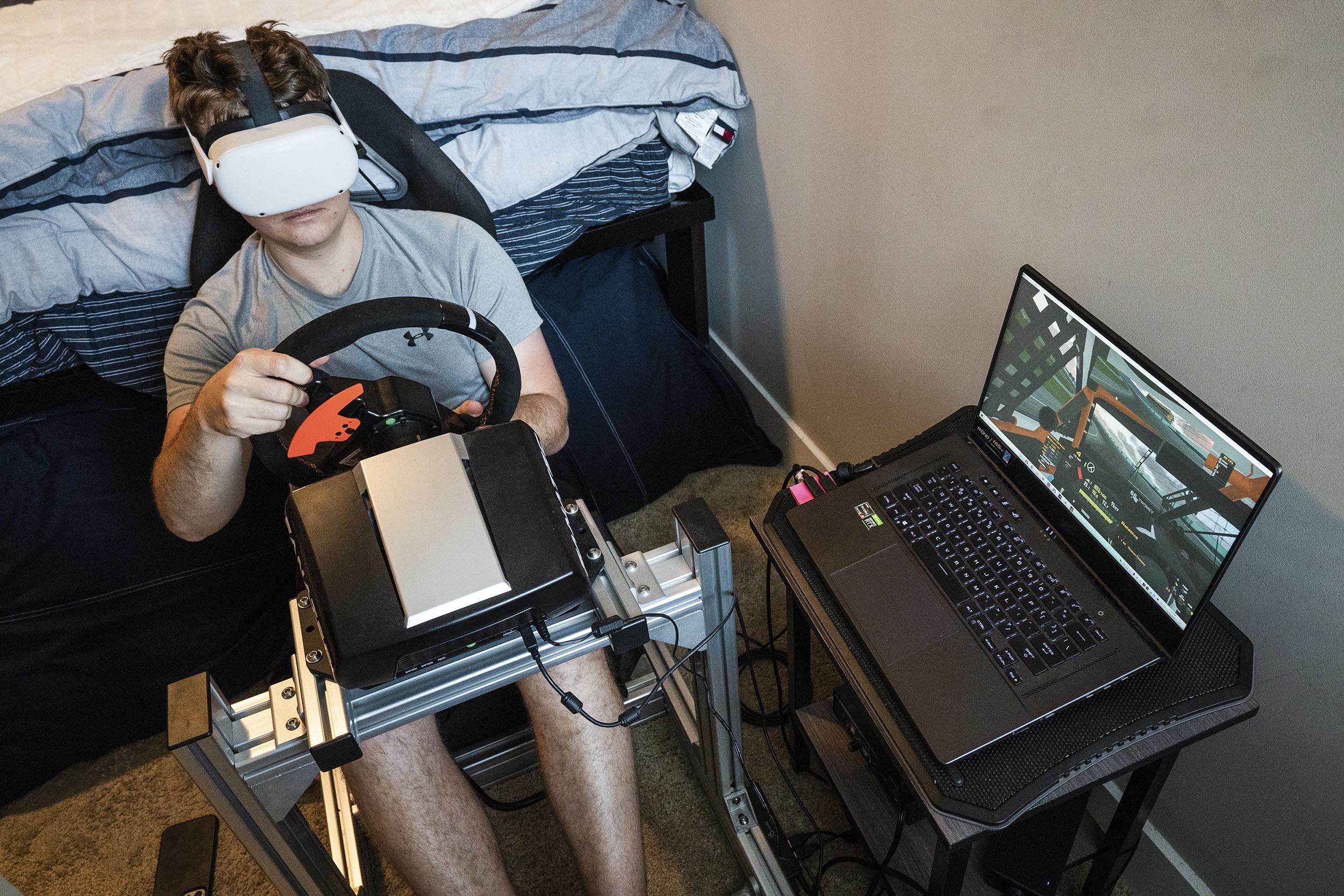 Thomas Twomey playing a video while demonstrating his virtual race car