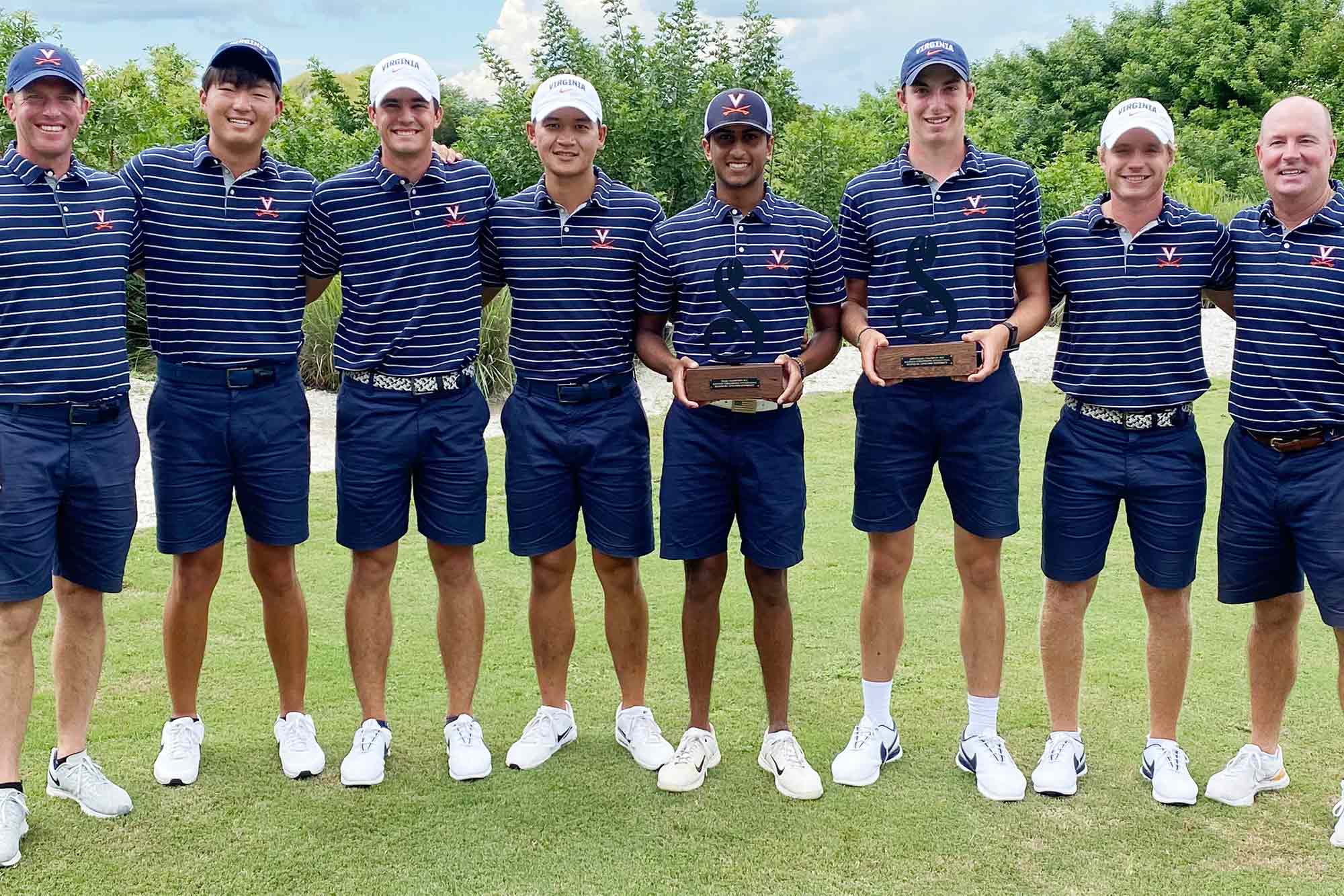 UVA Golf team holding trophies