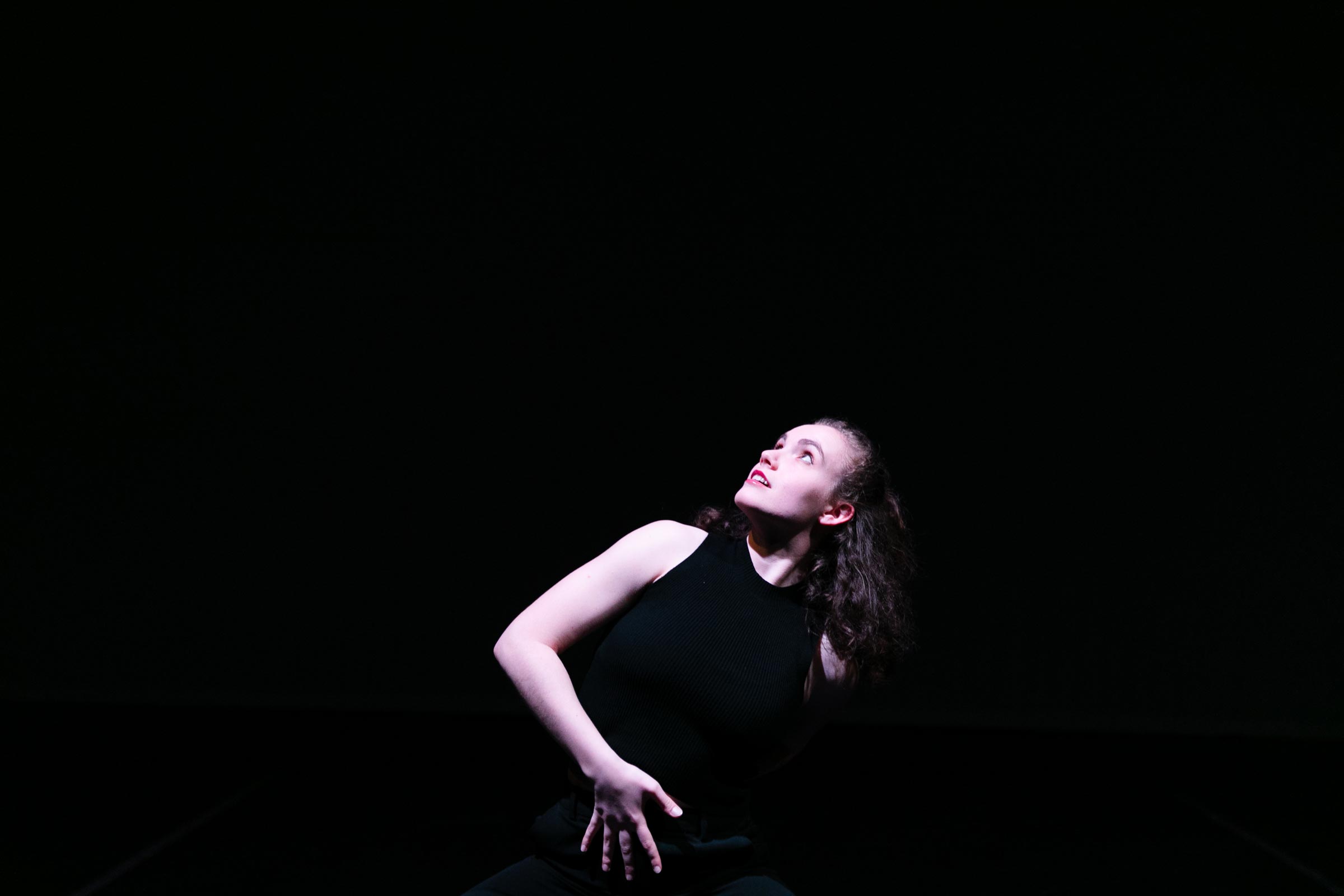 Zoe Ziff dances, dressed in black, on a black background