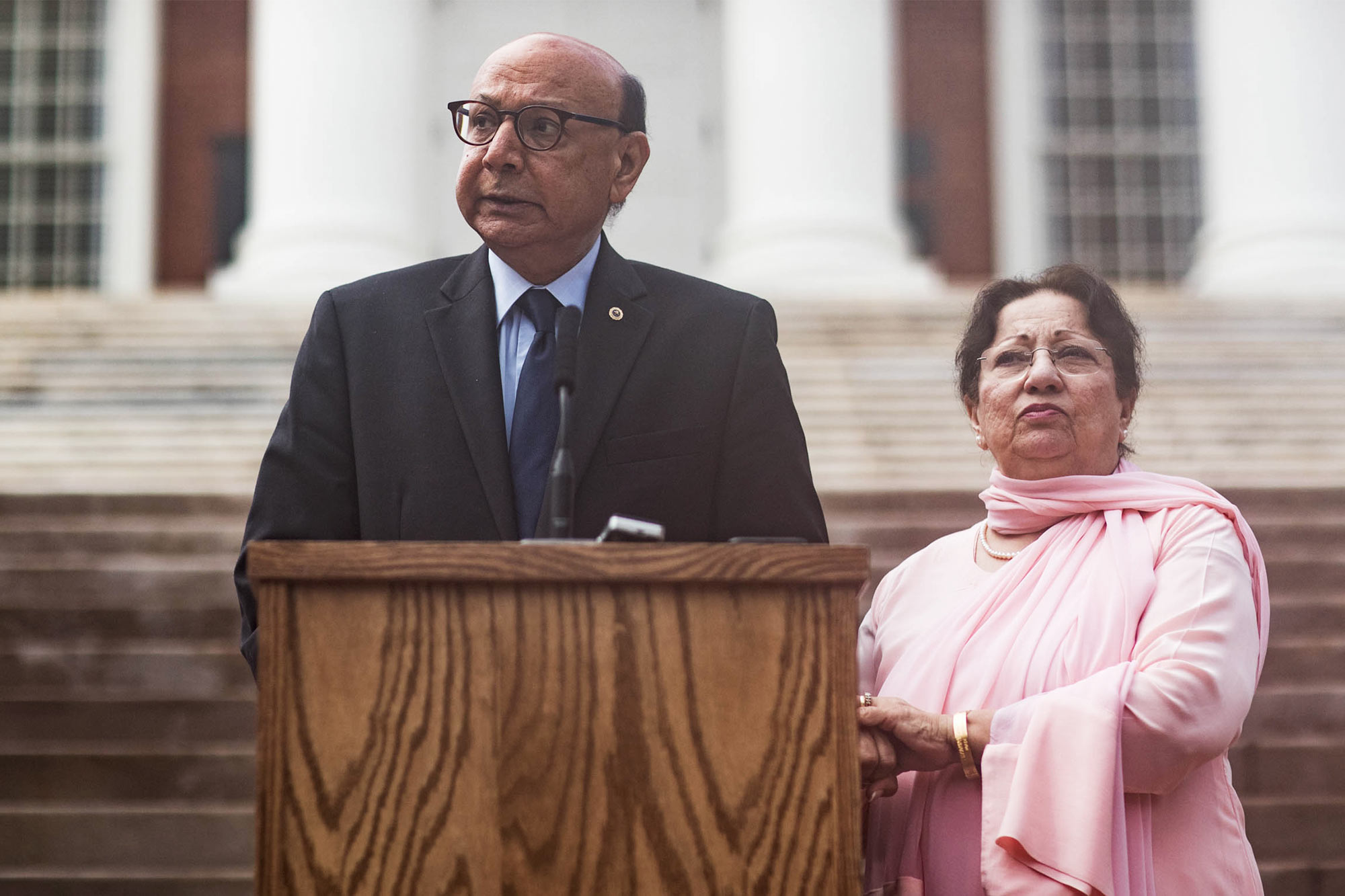 Khizr Khan stands at a podium in front of the UVA Rotunda. Ghazala Khan stands next to him.