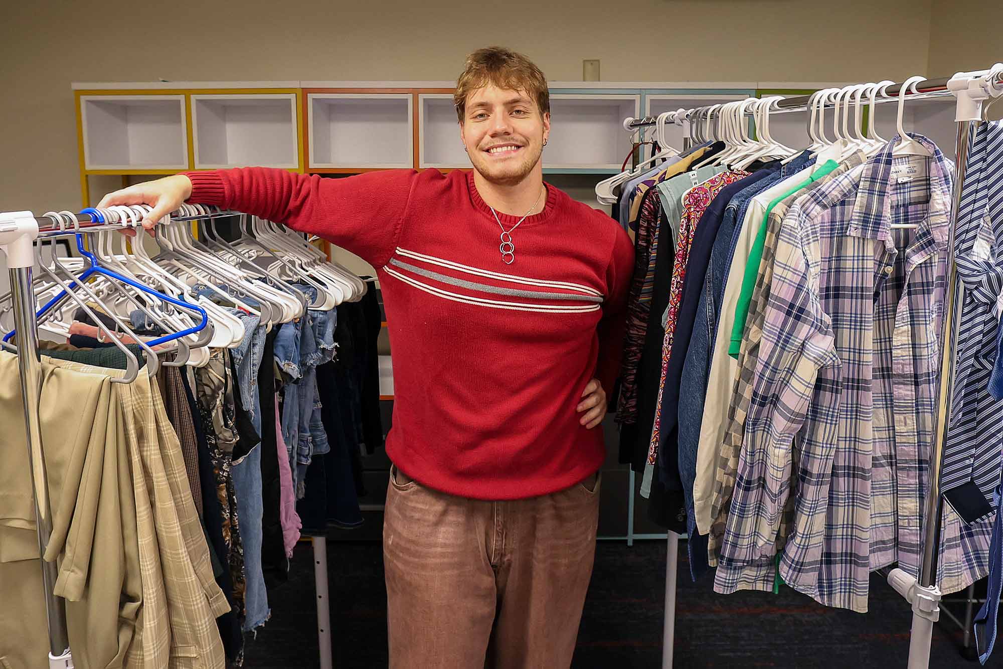 Clay Dickerson standing between two racks of clothes