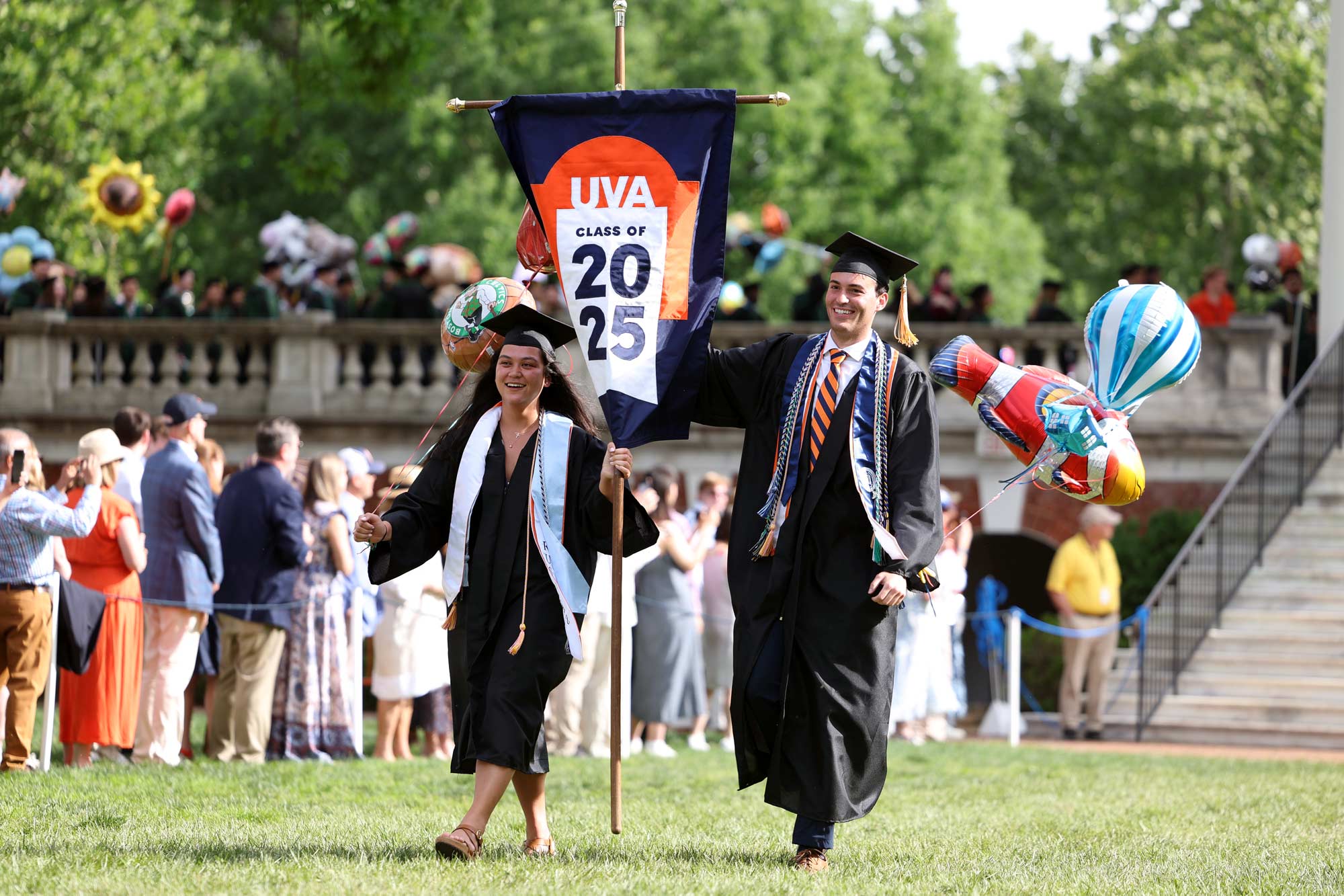 Liv Schortmann, left, and James Edwards, right, processing down the Lawn holding the Class of 2025 banner