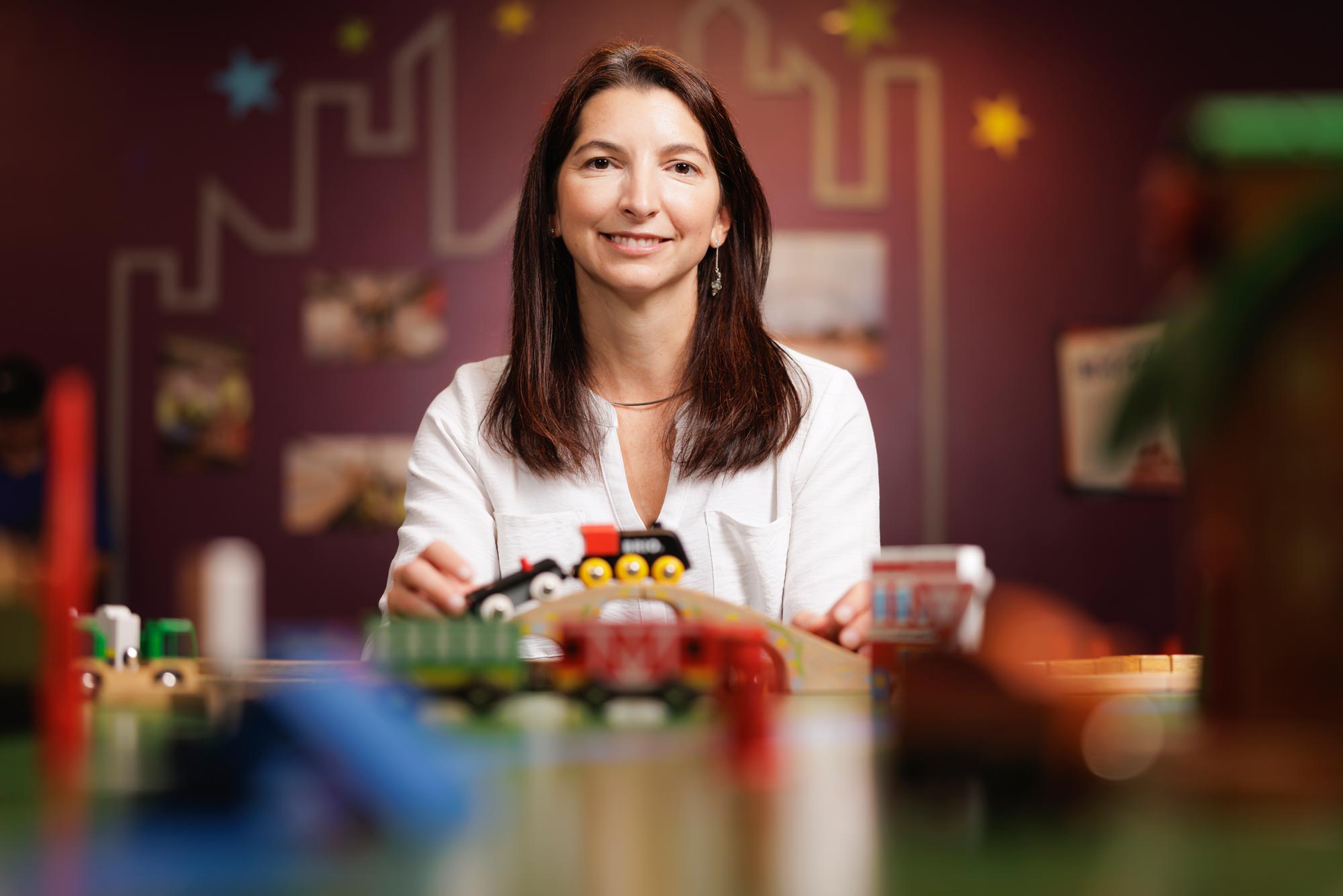 Jamie Jirout seated at a table with children's toys