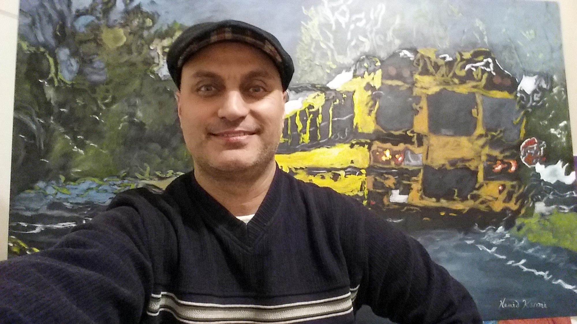 Jim Karimi in front of painting of a school bus