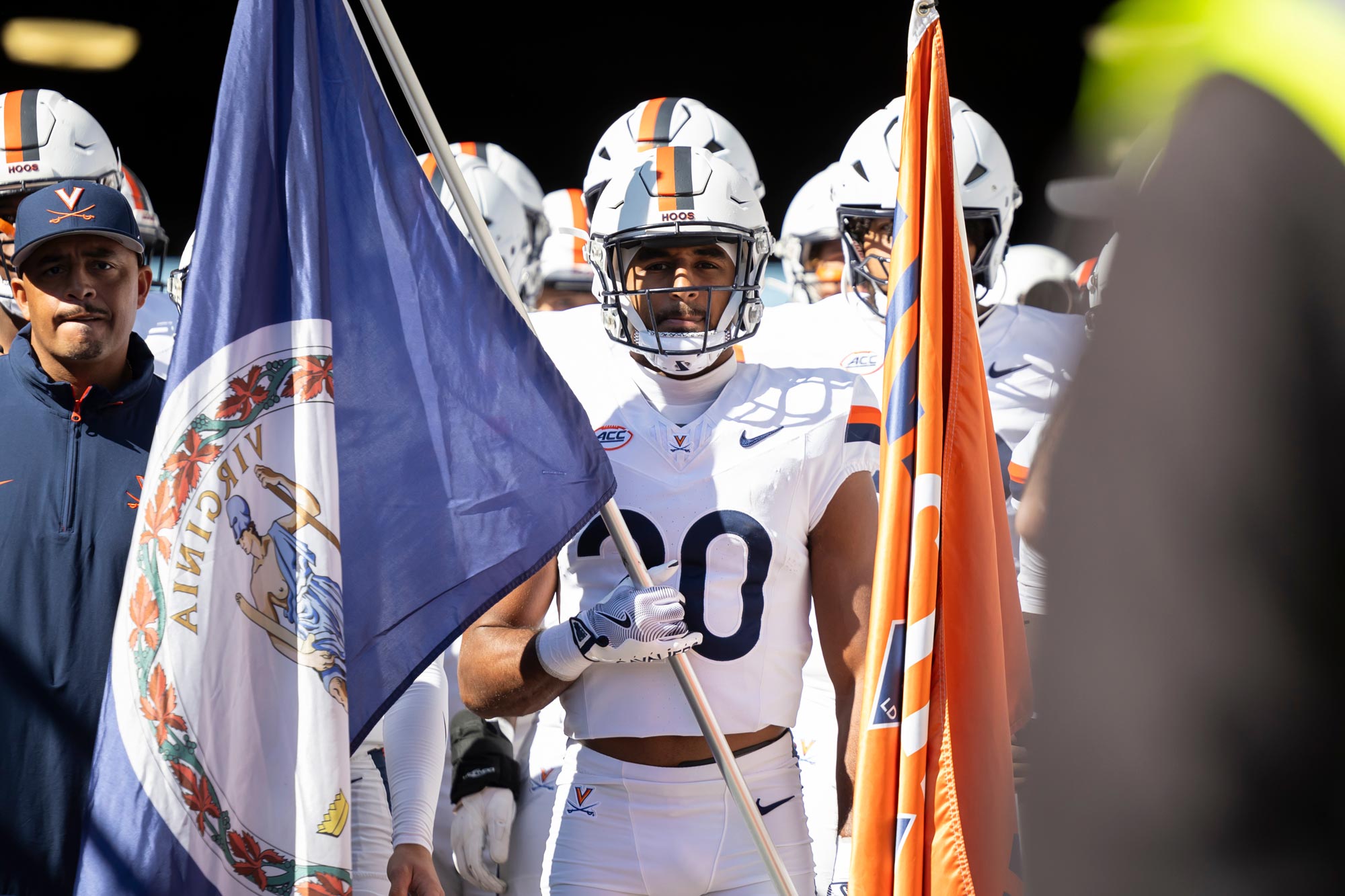 Jonas Sanker holding a flag while walking onto the field