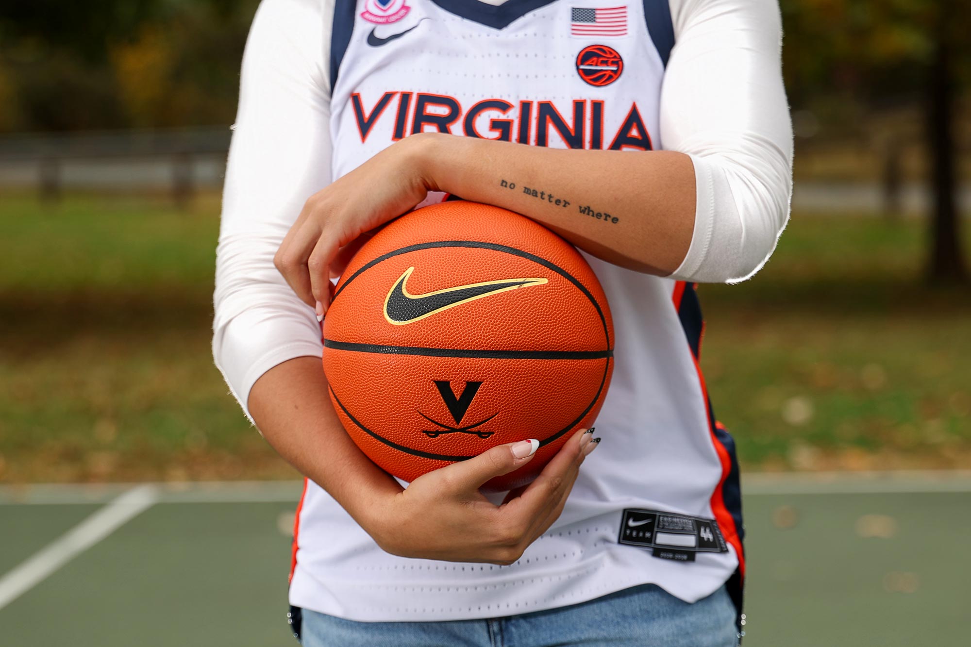 Close up of Kymora Johnson’s tattoo and a UVA basketball
