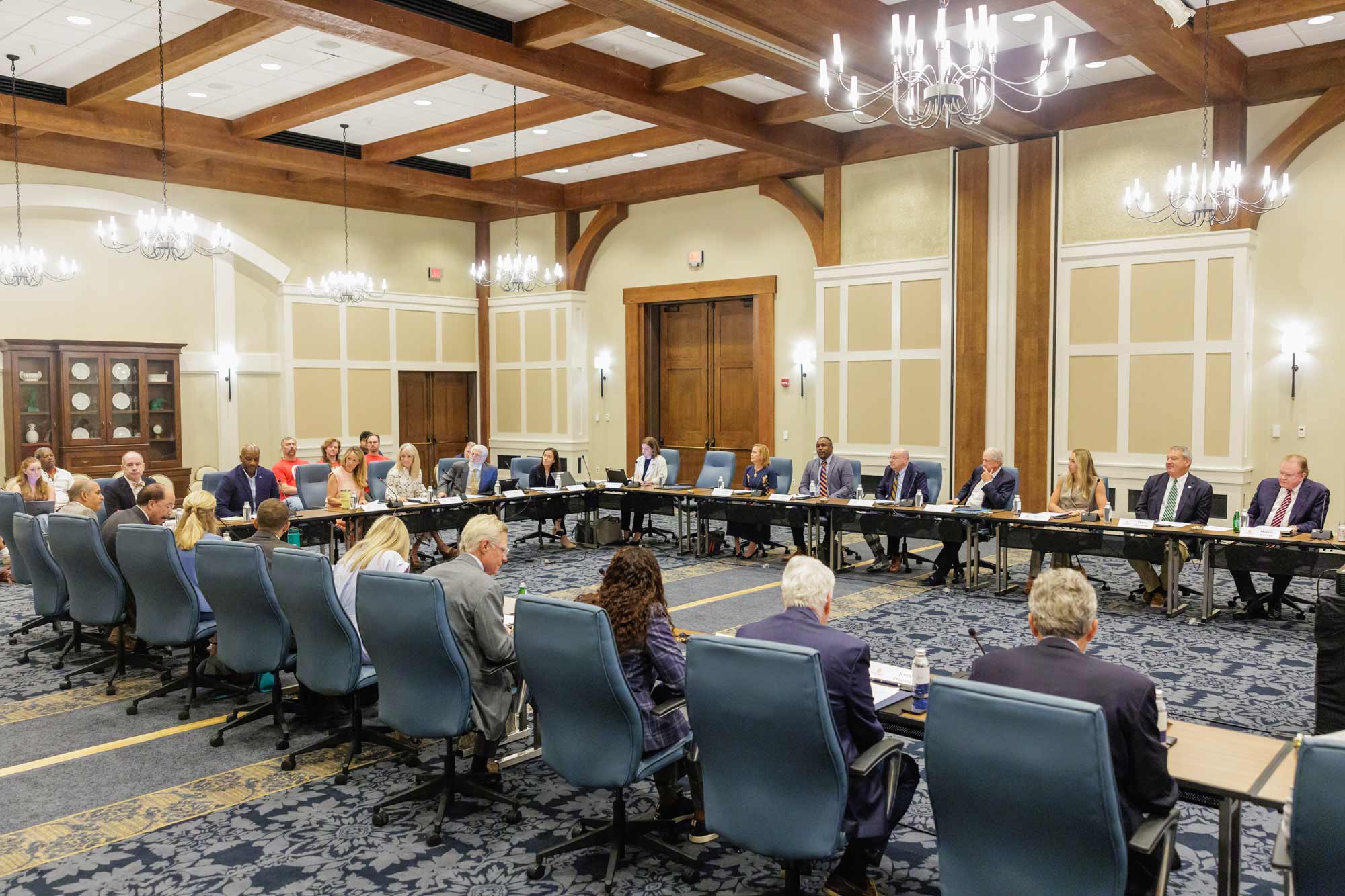 The full presidential search committee sitting together around a table