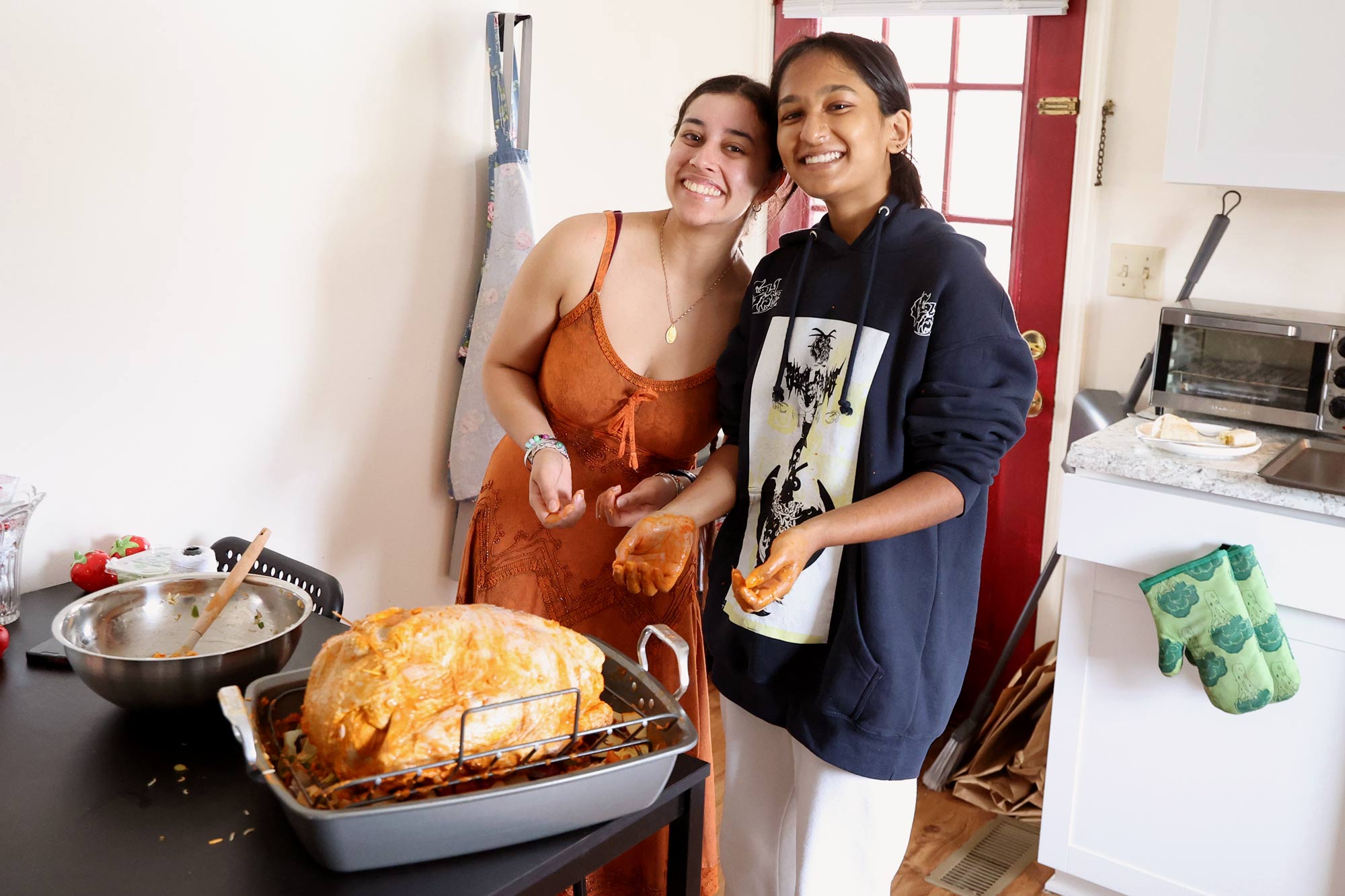 Third-year chemical engineering students Harkiran Singh, left, and Preyonty Rabbani prepare to put their winning tandoori turkey in the oven. 